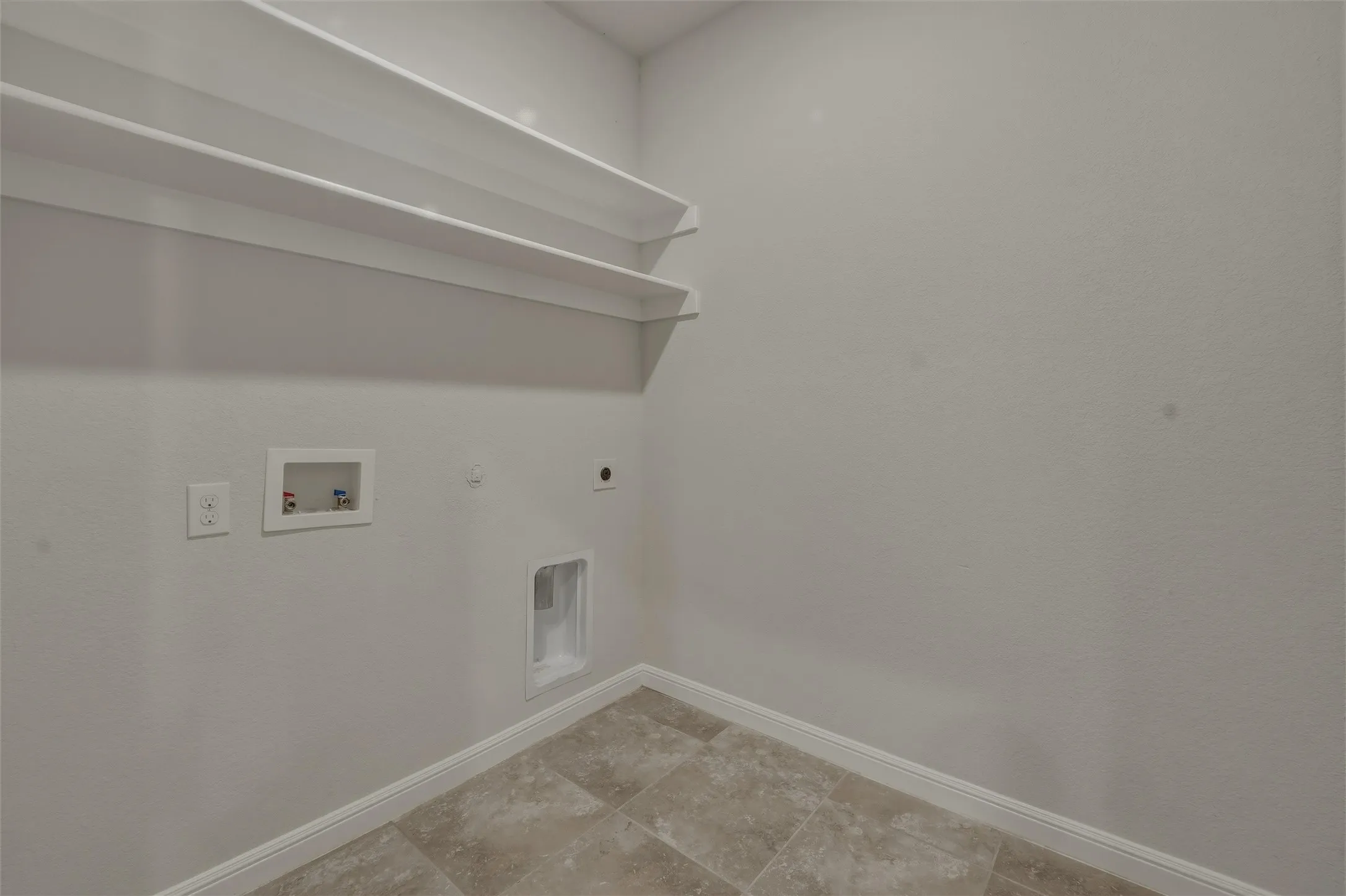 Utility space featuring neutral wall paint, white baseboards, and ceramic tile flooring