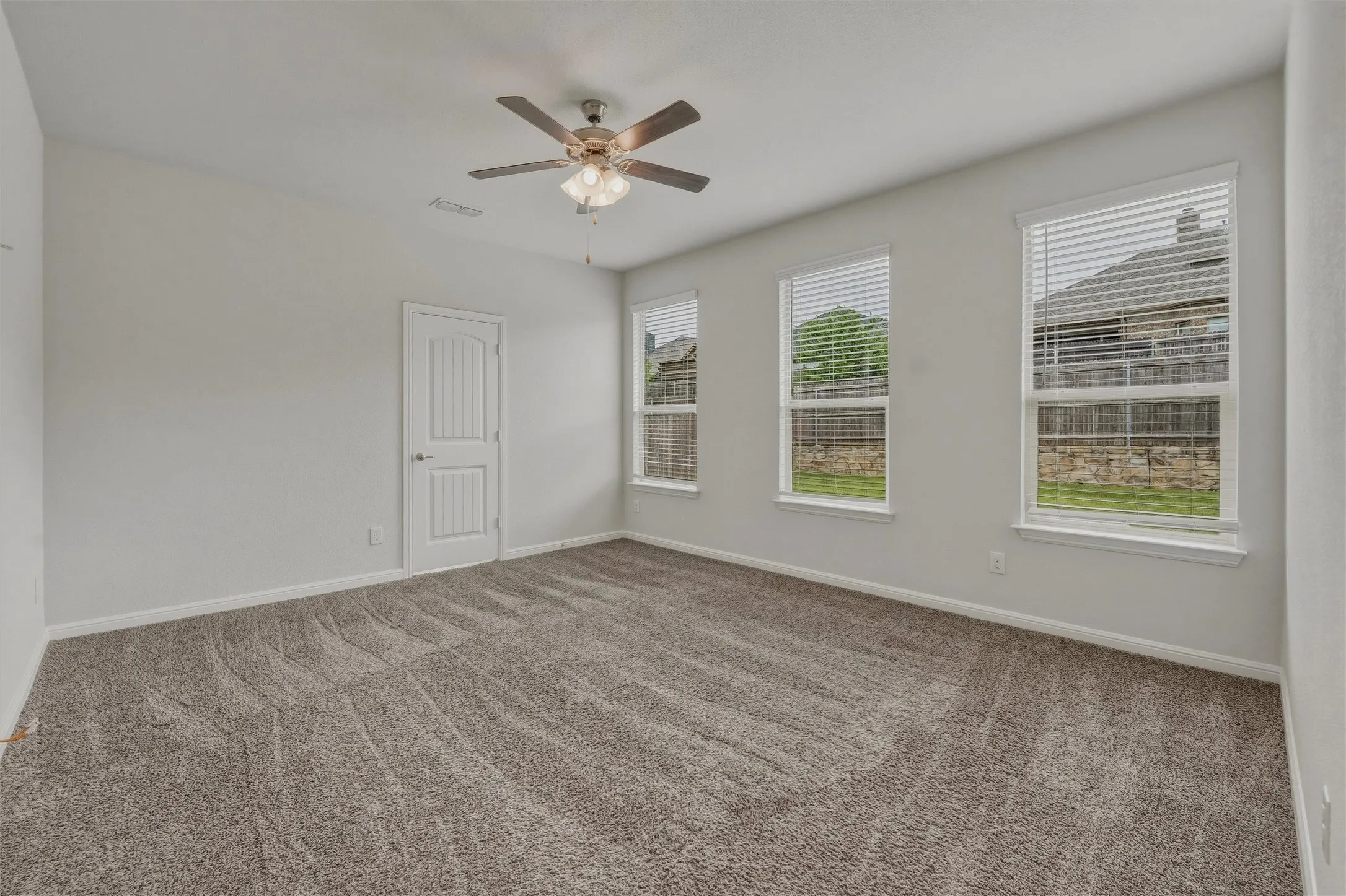 Spacious room featuring neutral carpeting and light-toned walls