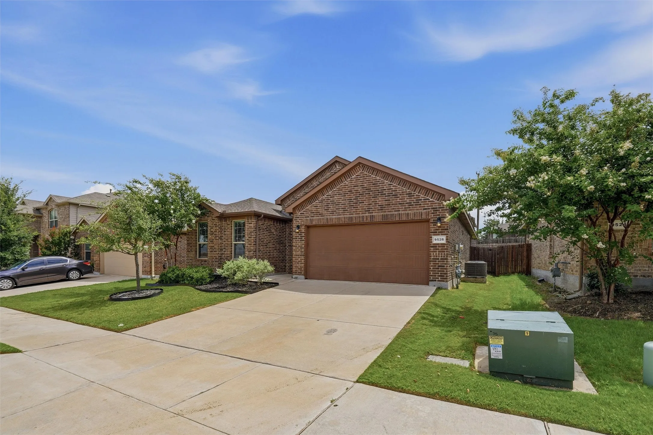 Brick exterior featuring an attached garage and concrete driveway