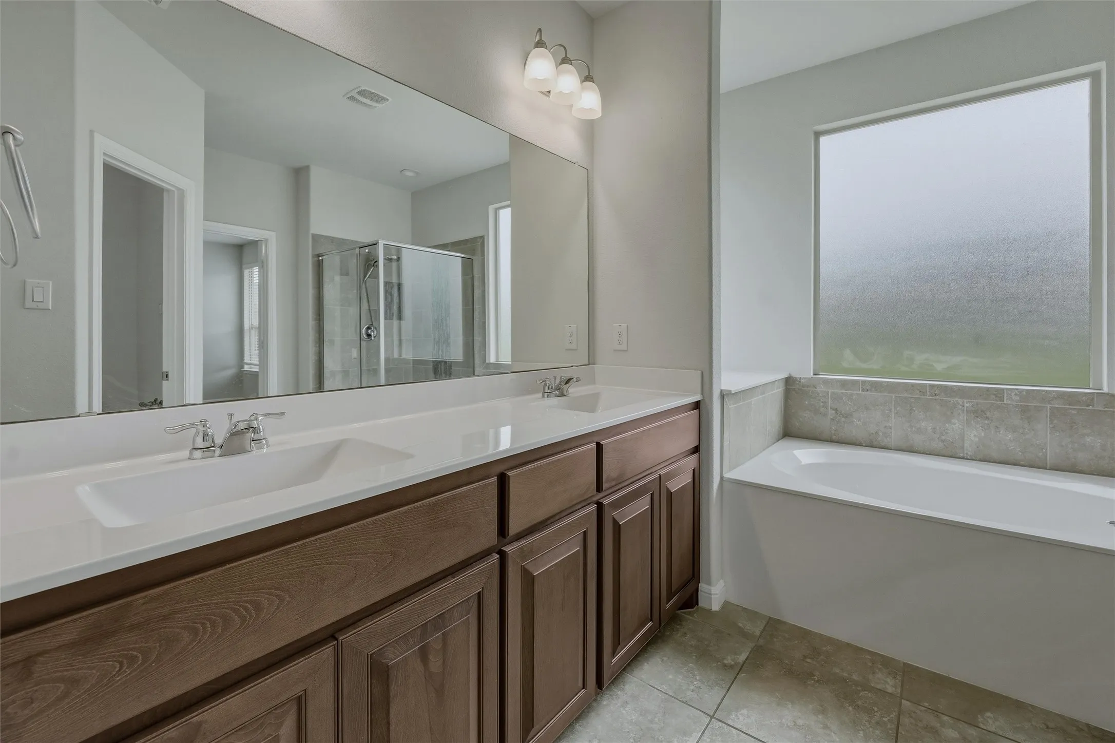 Bathroom featuring a double vanity with wood-finish cabinetry and white countertops