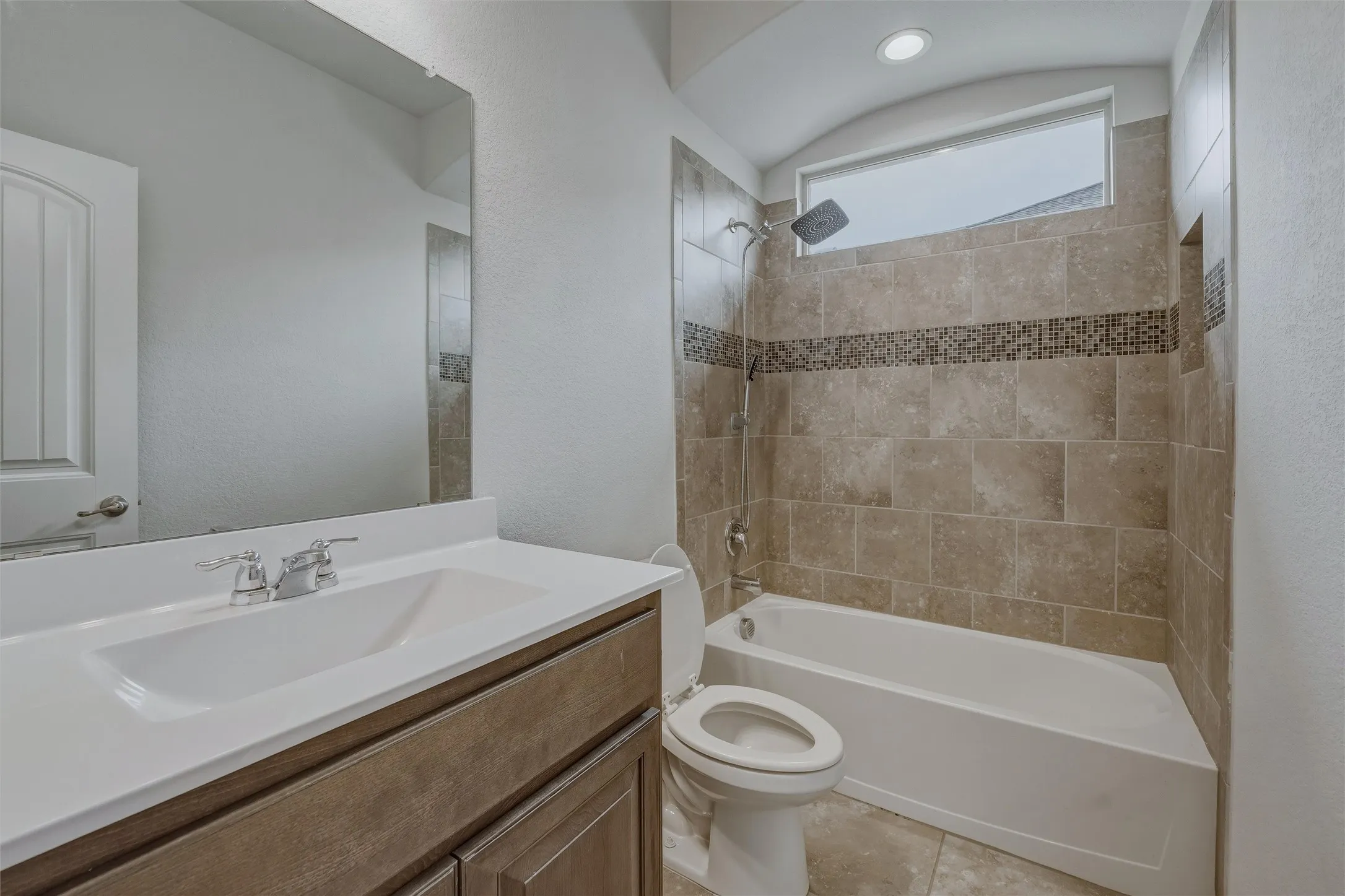 Bathroom featuring a vanity with a white countertop and integrated sink, chrome faucet, and wood-finish cabinetry