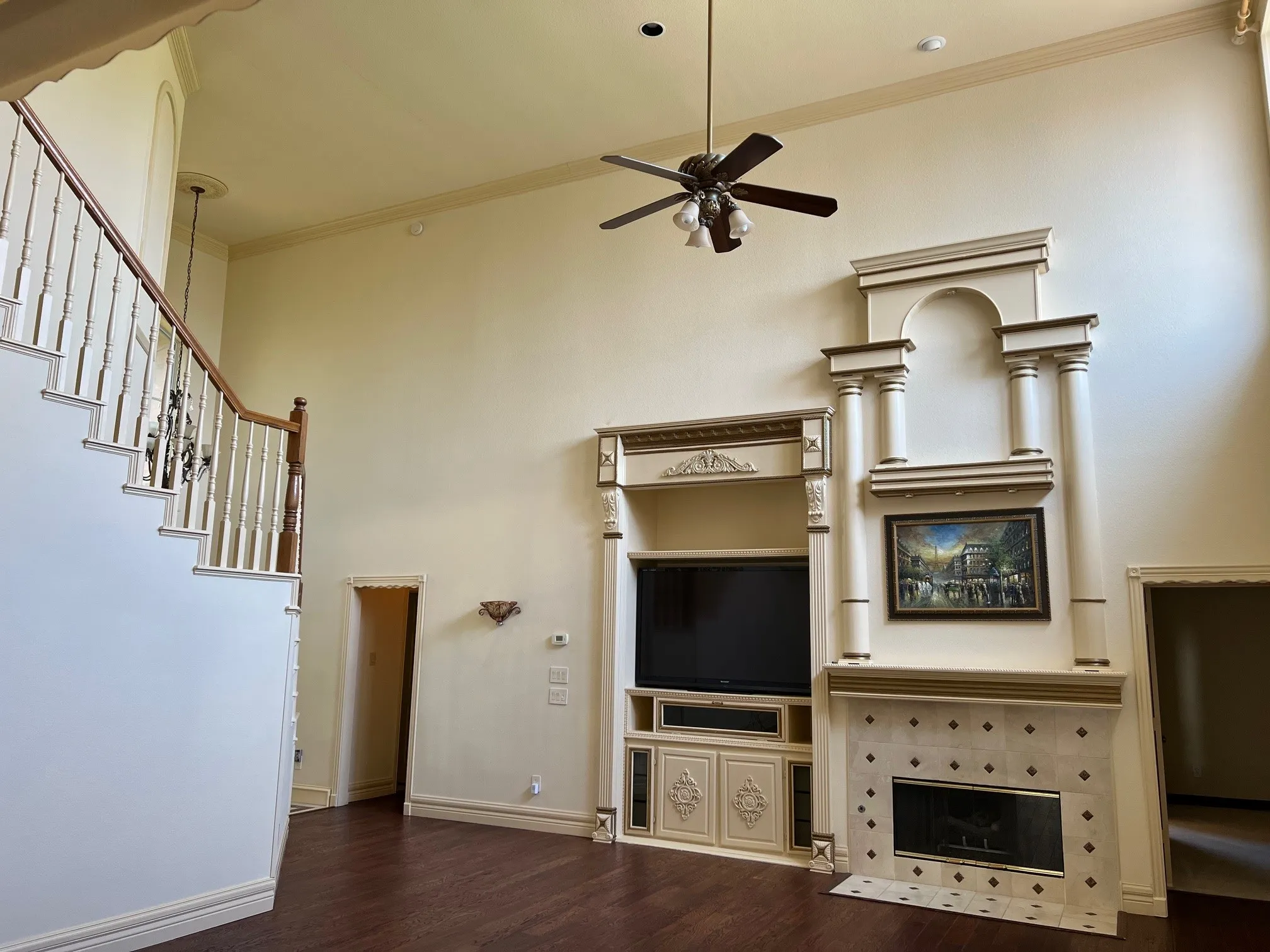 Unfurnished living room featuring a fireplace, ornamental molding, ceiling fan, and dark hardwood / wood-style floors