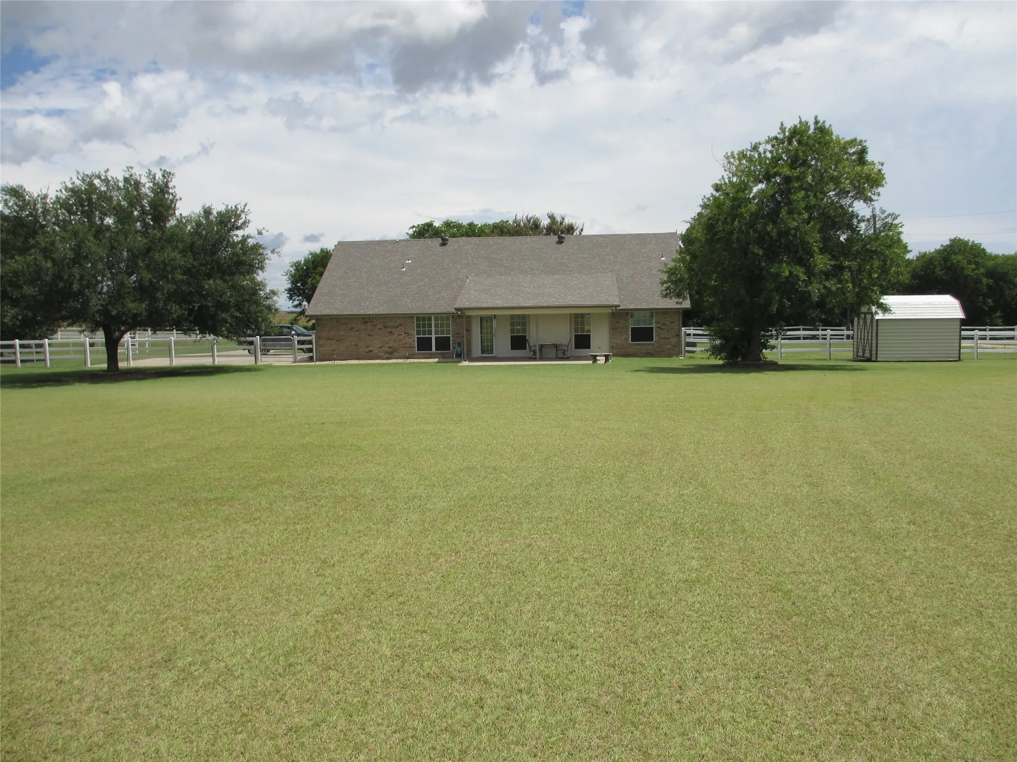 Back of Home with two large Live Oak trees