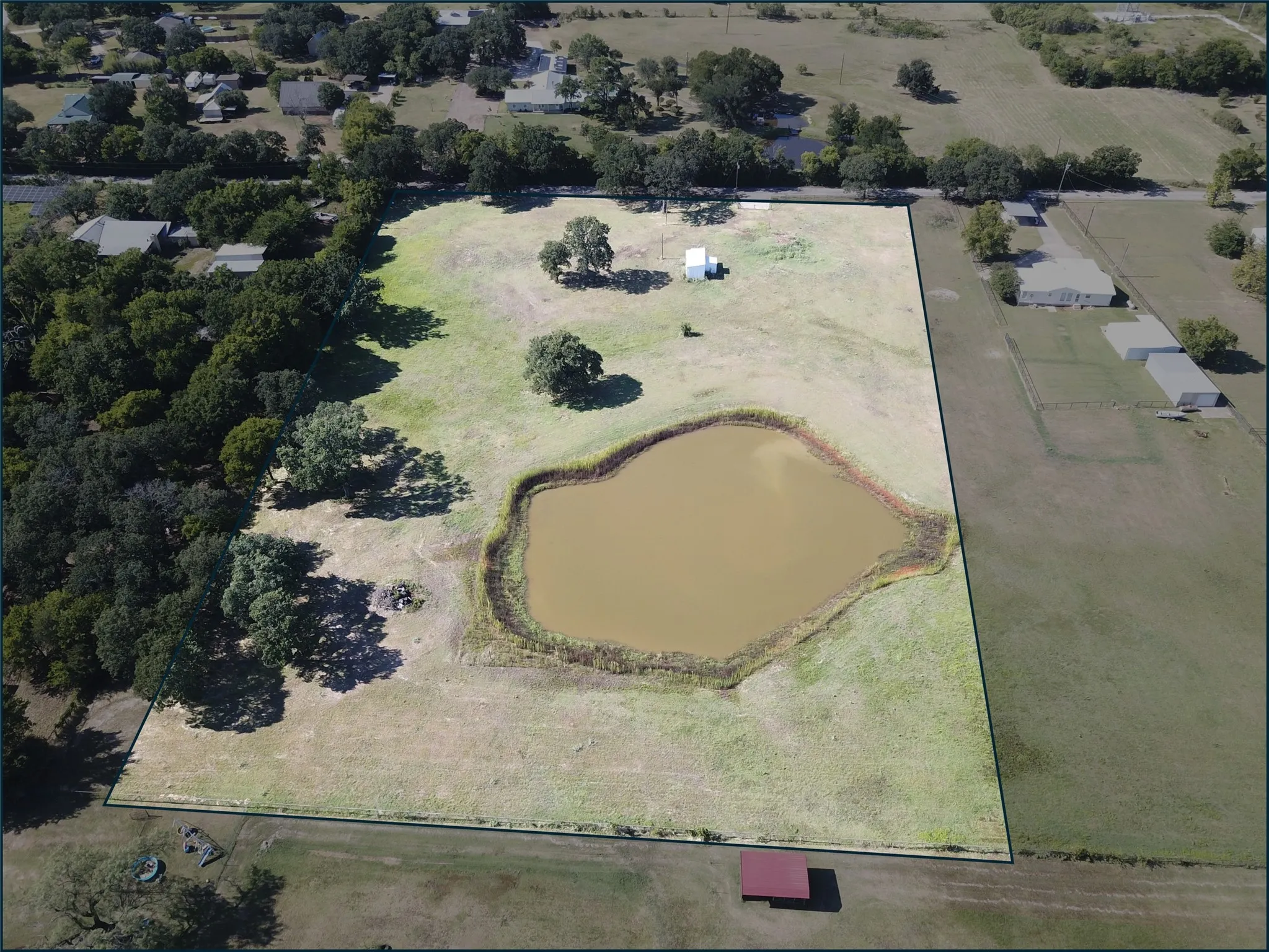 Back view of property featuring a large pond, surrounding green space, and mature trees - Perimeter is an estimate