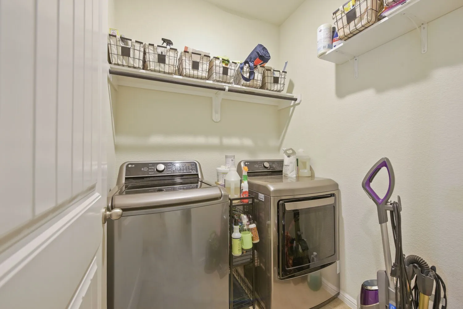 Laundry area featuring light-colored walls and built-in shelving