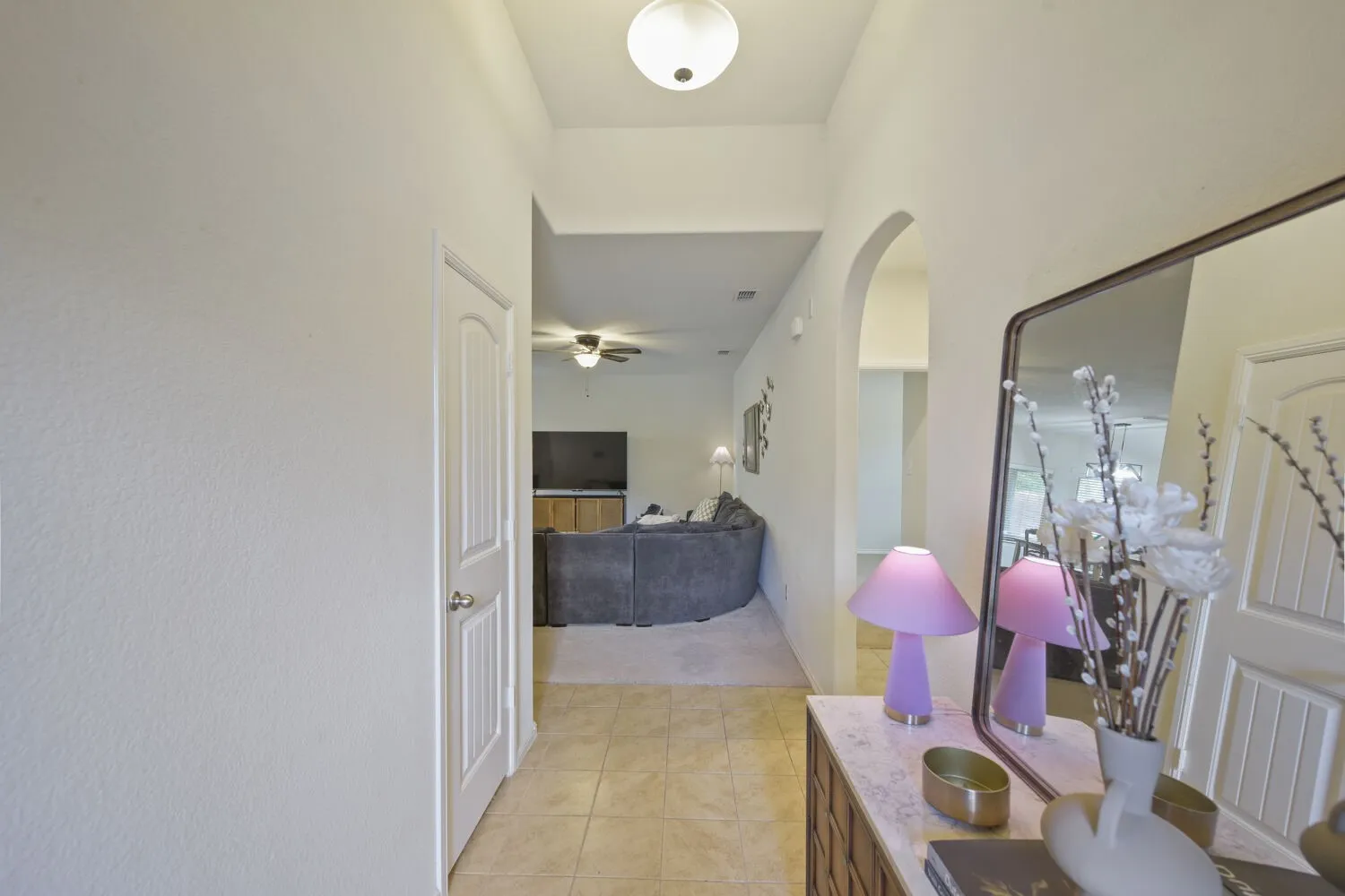Entryway featuring tile flooring, an arched doorway, and a flush mount ceiling light