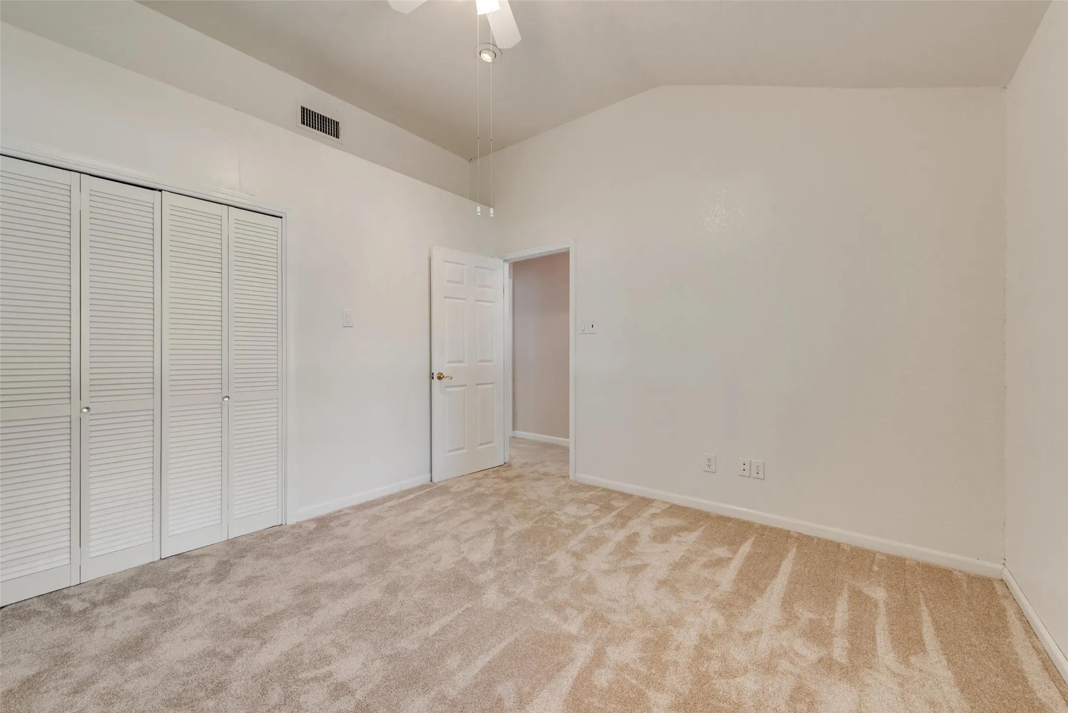 Third bedroom featuring a vaulted ceiling