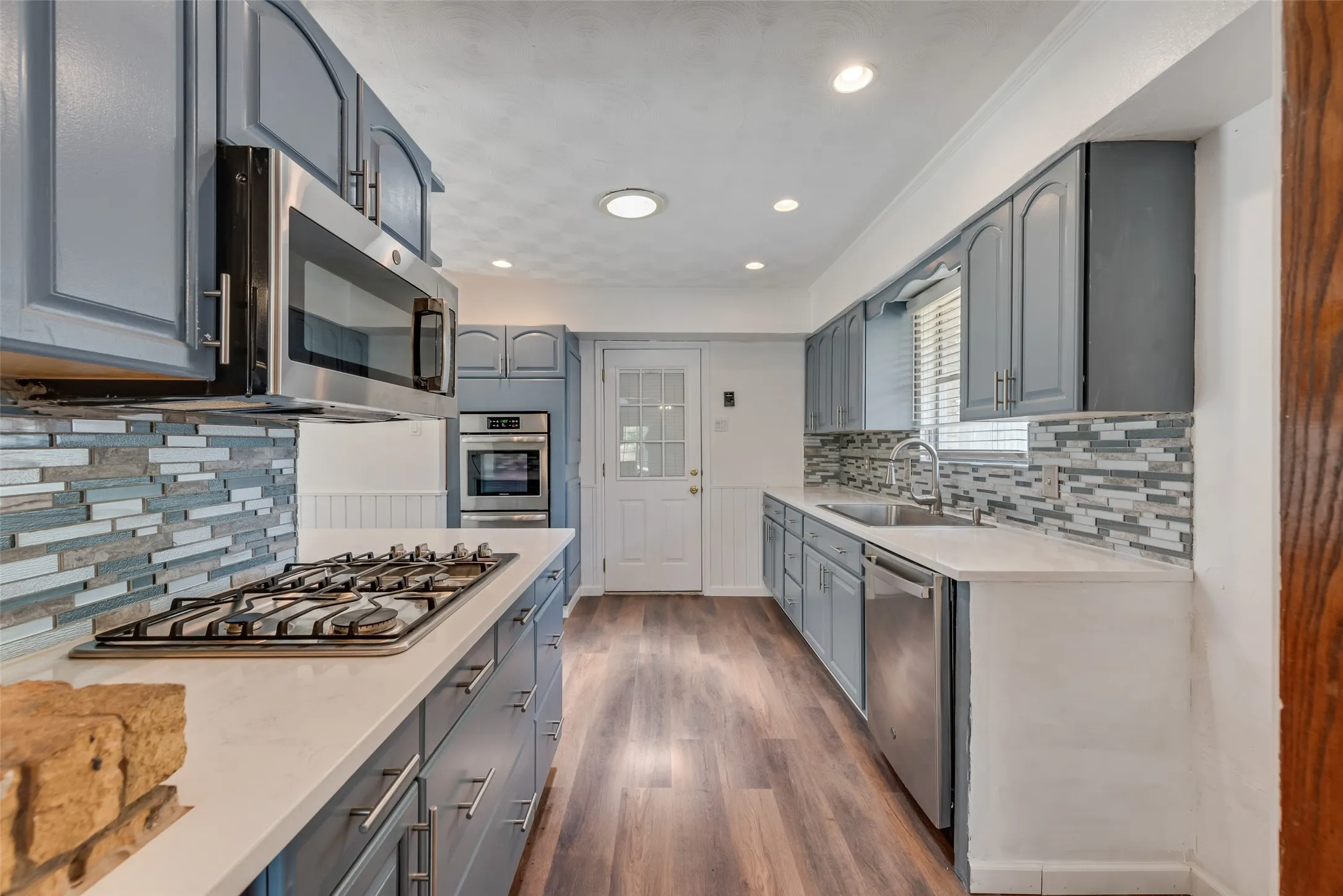 Updated kitchen featuring quartz countertops and stainless steel appliances