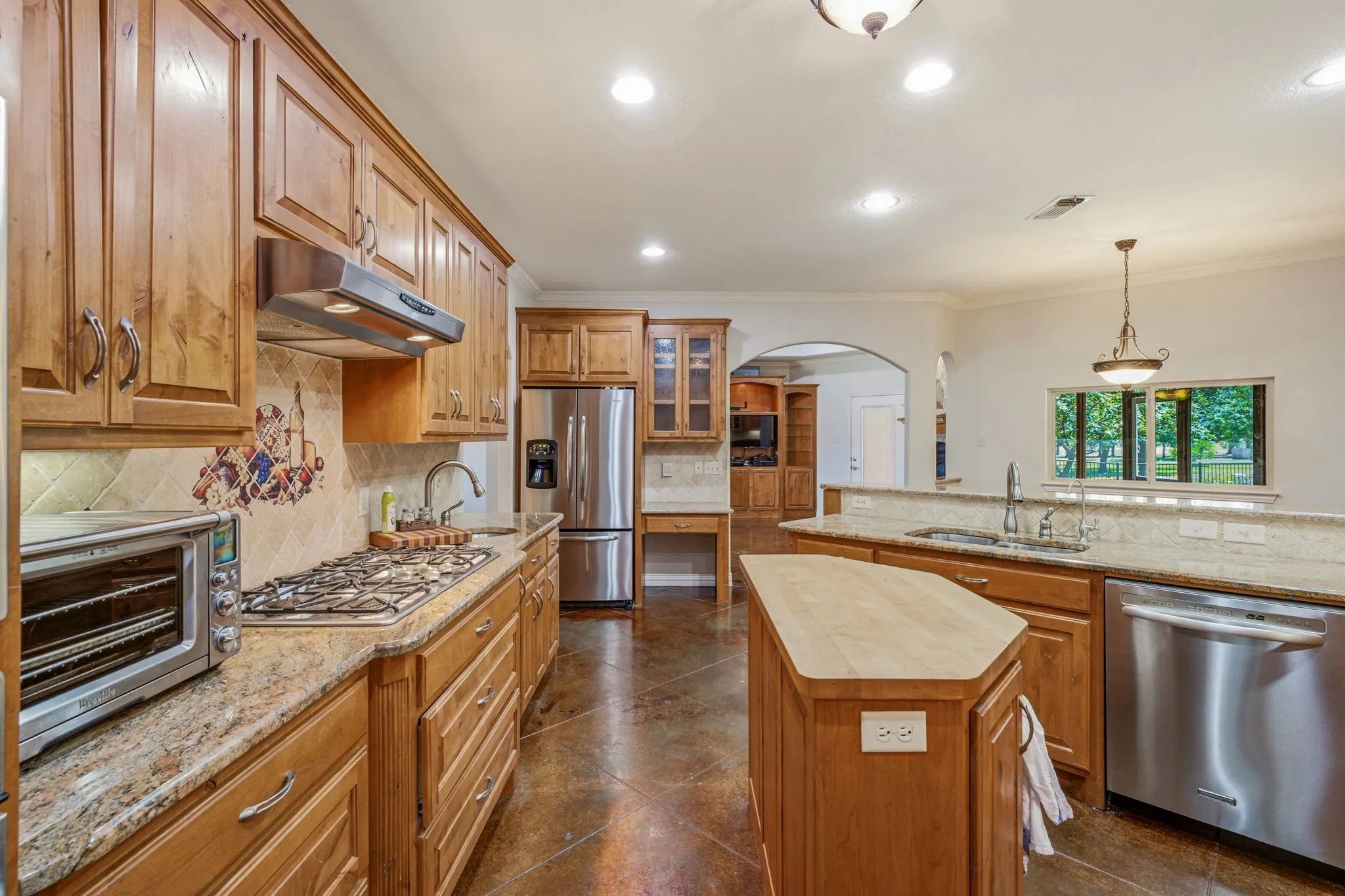 Kitchen featuring wood cabinetry, stainless steel appliances, and granite countertops