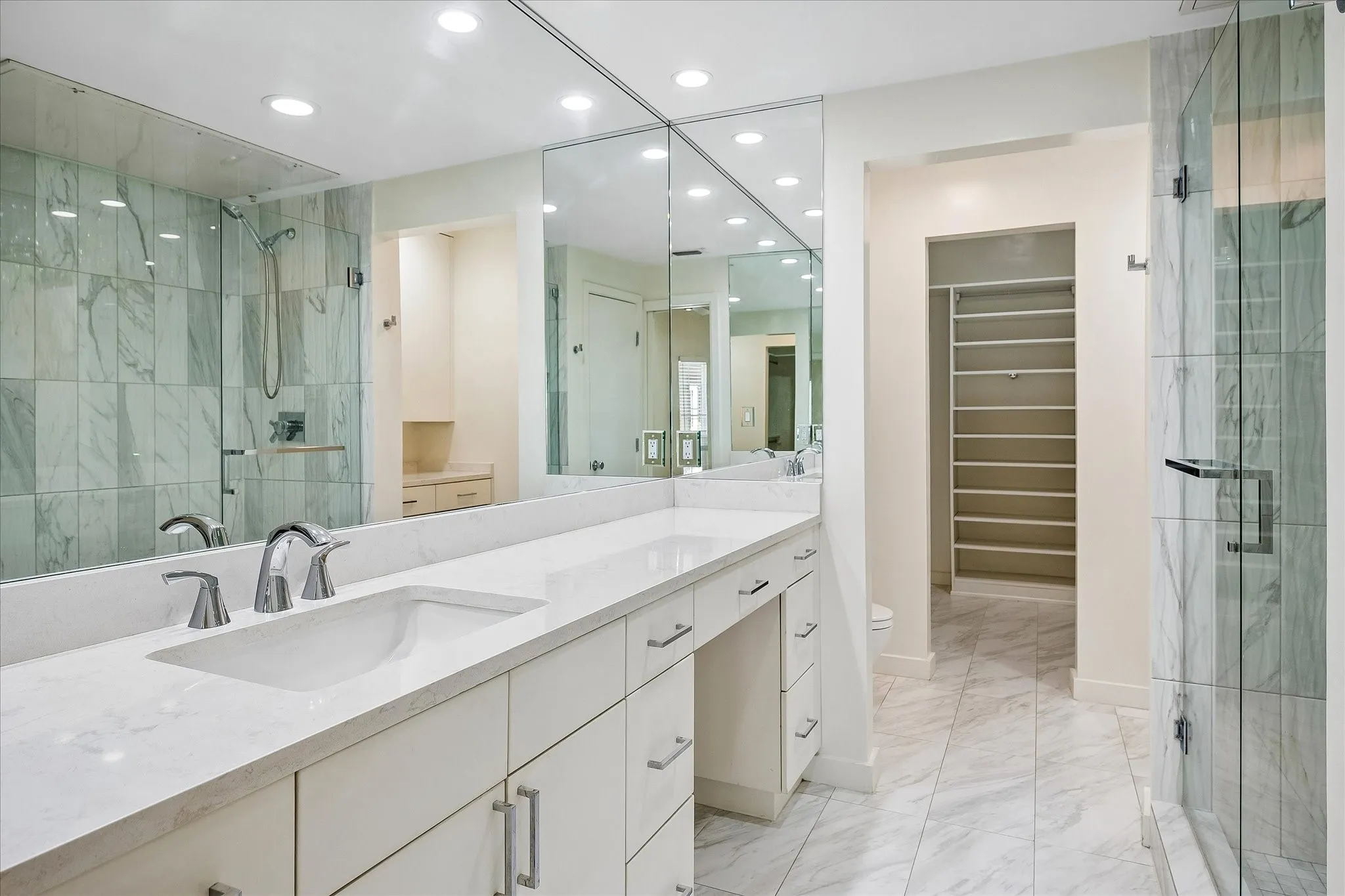 Updated ensuite primary bathroom with a vanity area.