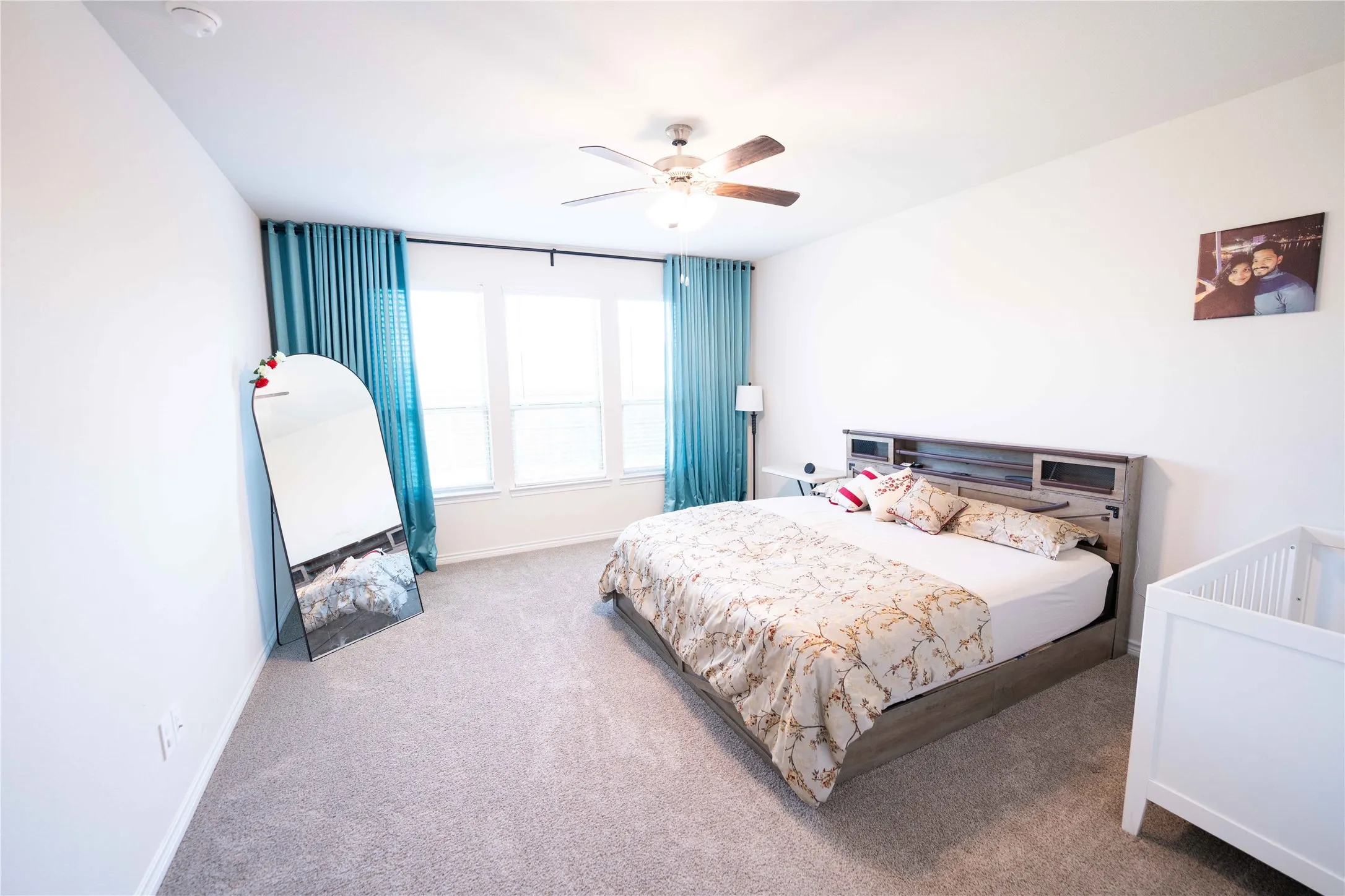 Carpeted sleeping area with white walls and a multi-pane window