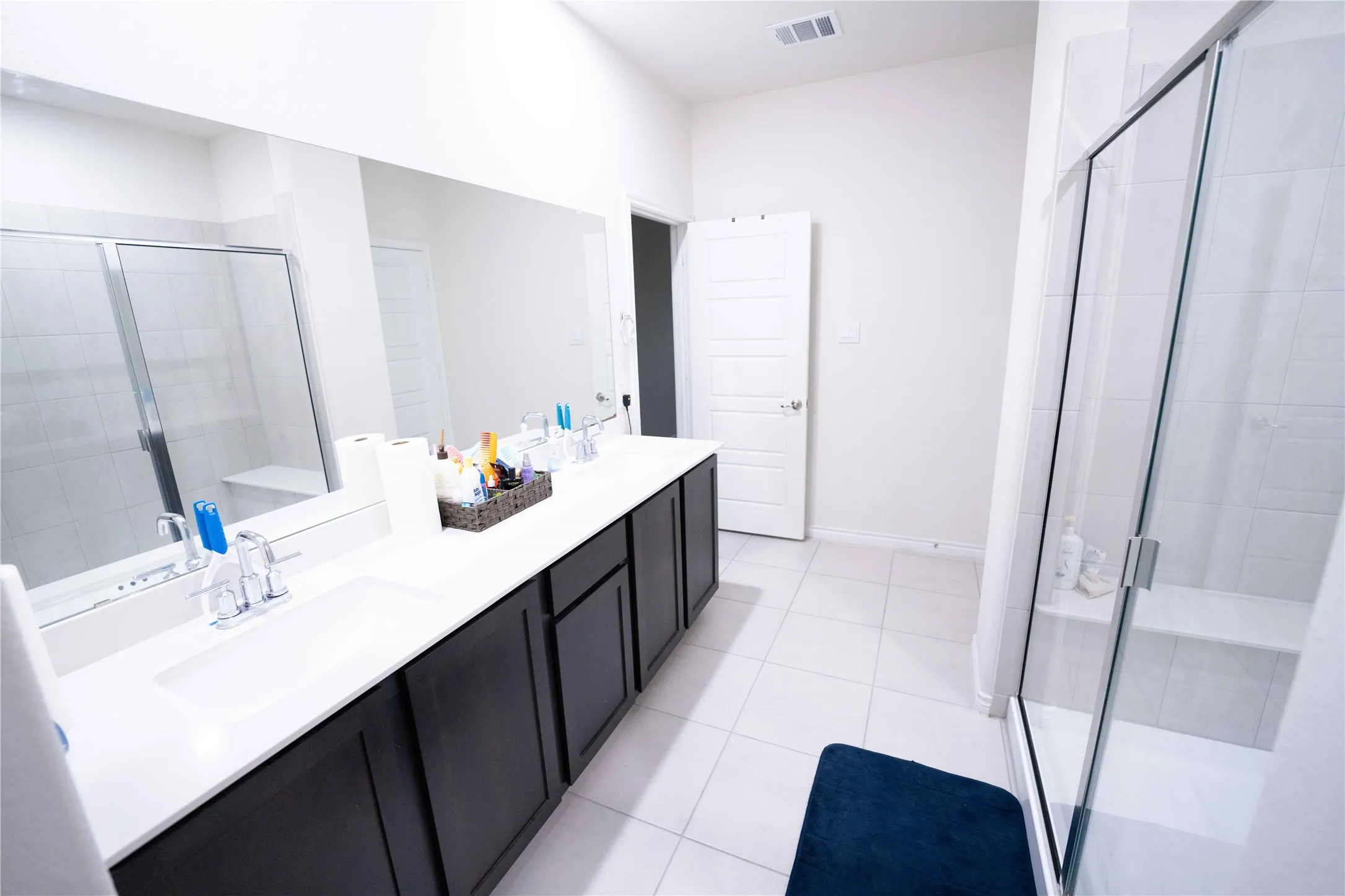 Bright bathroom with large format white tile flooring