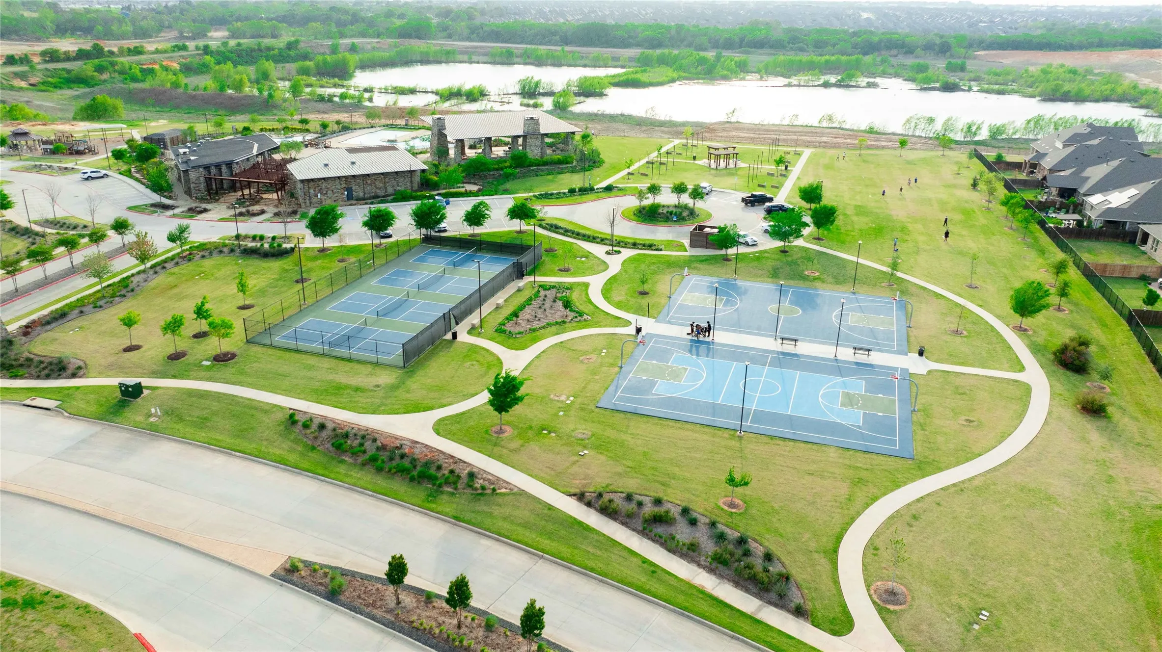 Expansive community park featuring multiple sports courts including two tennis courts and two basketball courts