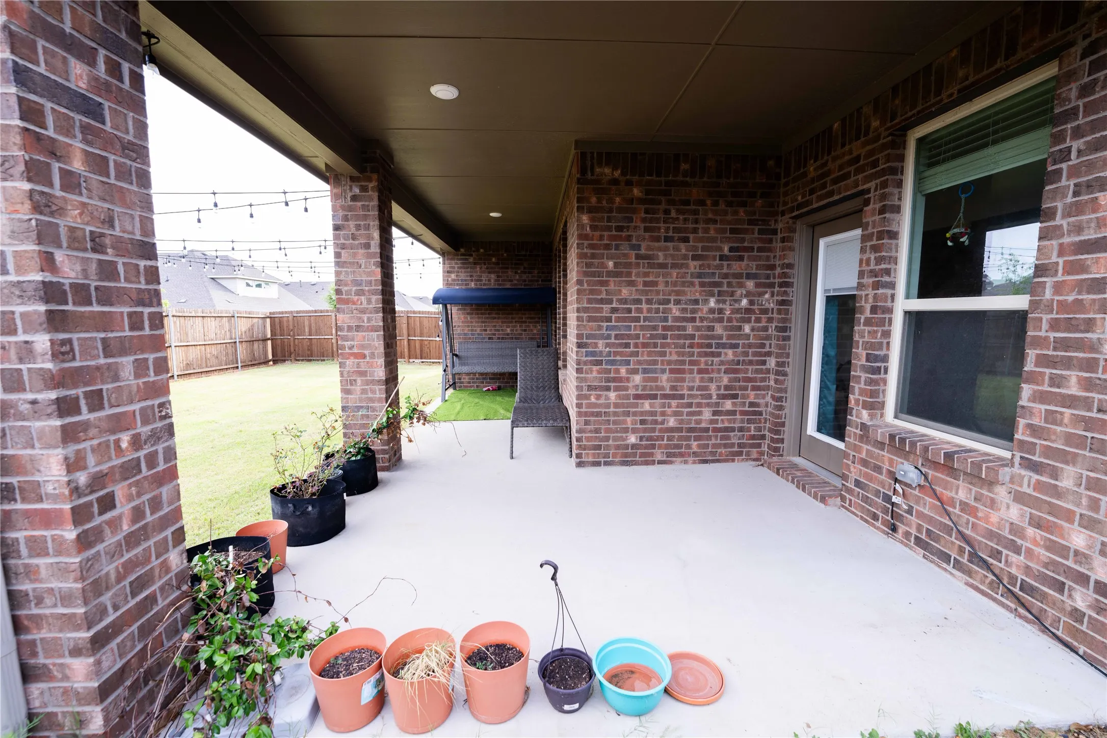 Covered patio with brick columns and a smooth concrete surface