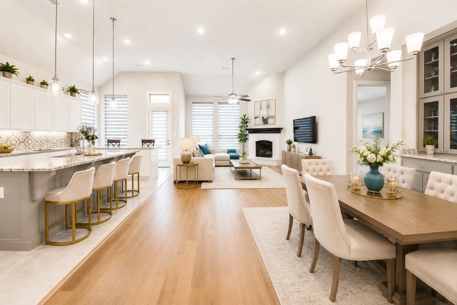Open-concept living space featuring wood-finish flooring, a kitchen island with stone countertops, a fireplace with a mantel, and high ceilings with recessed lighting