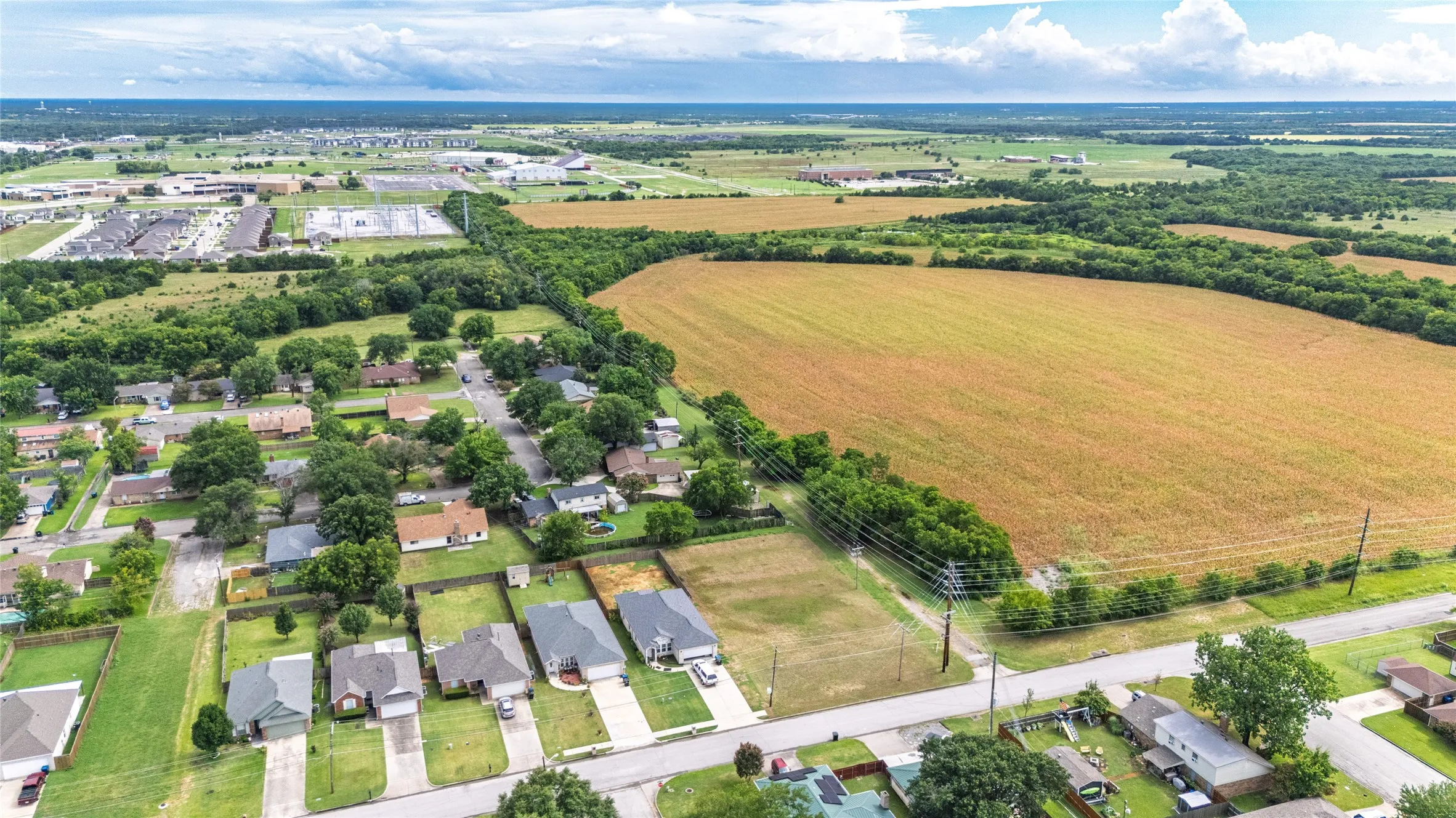 Expansive undeveloped land parcel with surrounding residential areas and agricultural fields