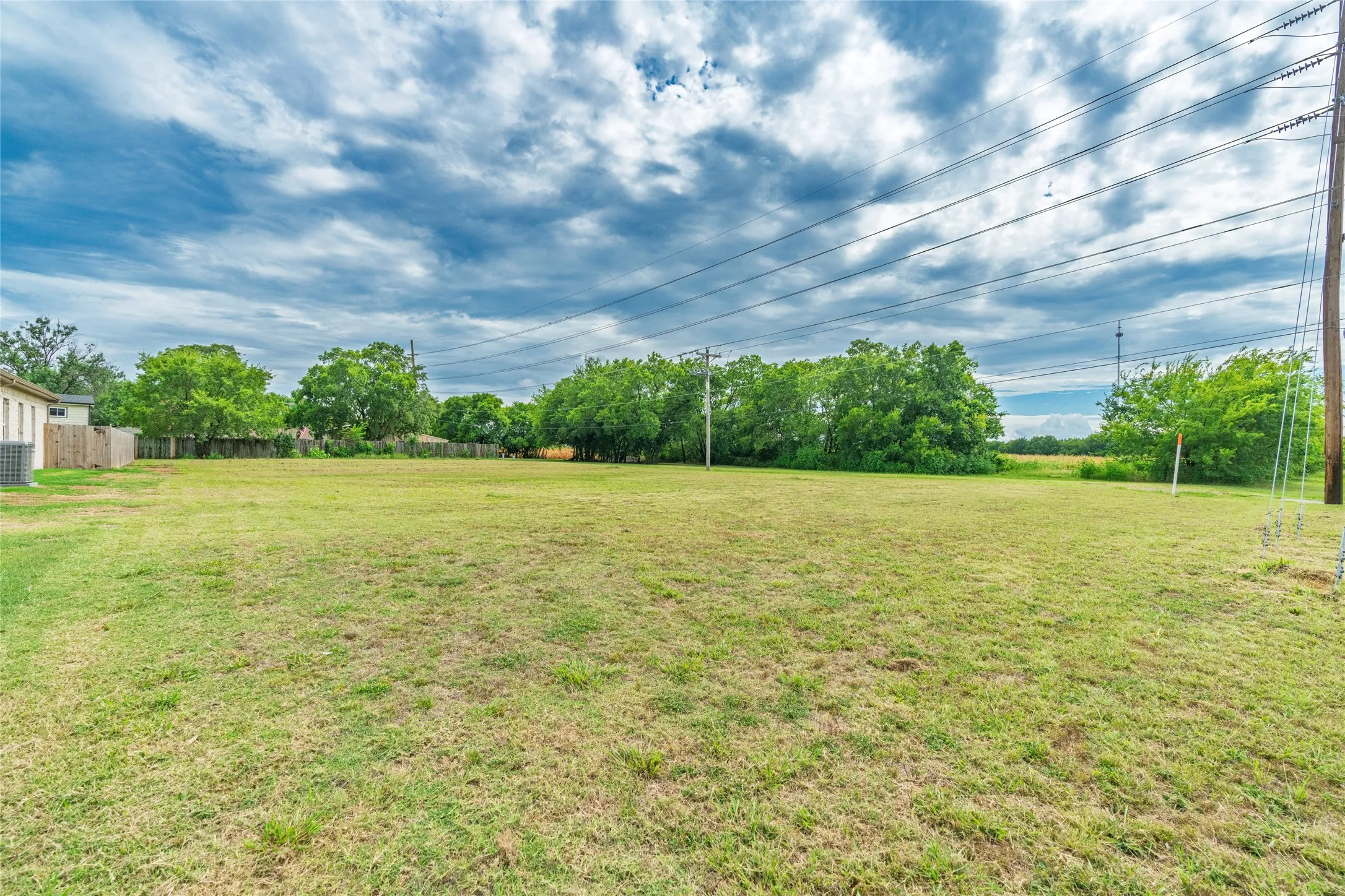 Expansive cleared lot with mature trees bordering the property