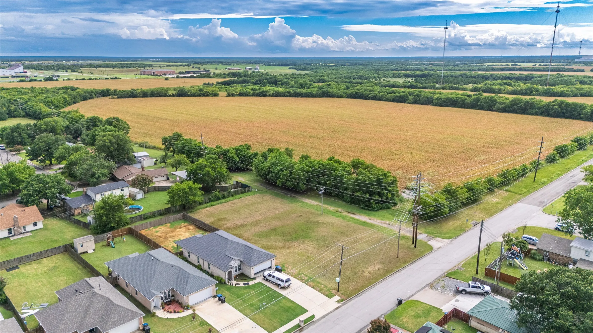 Expansive property featuring a large open field bordered by wooded areas