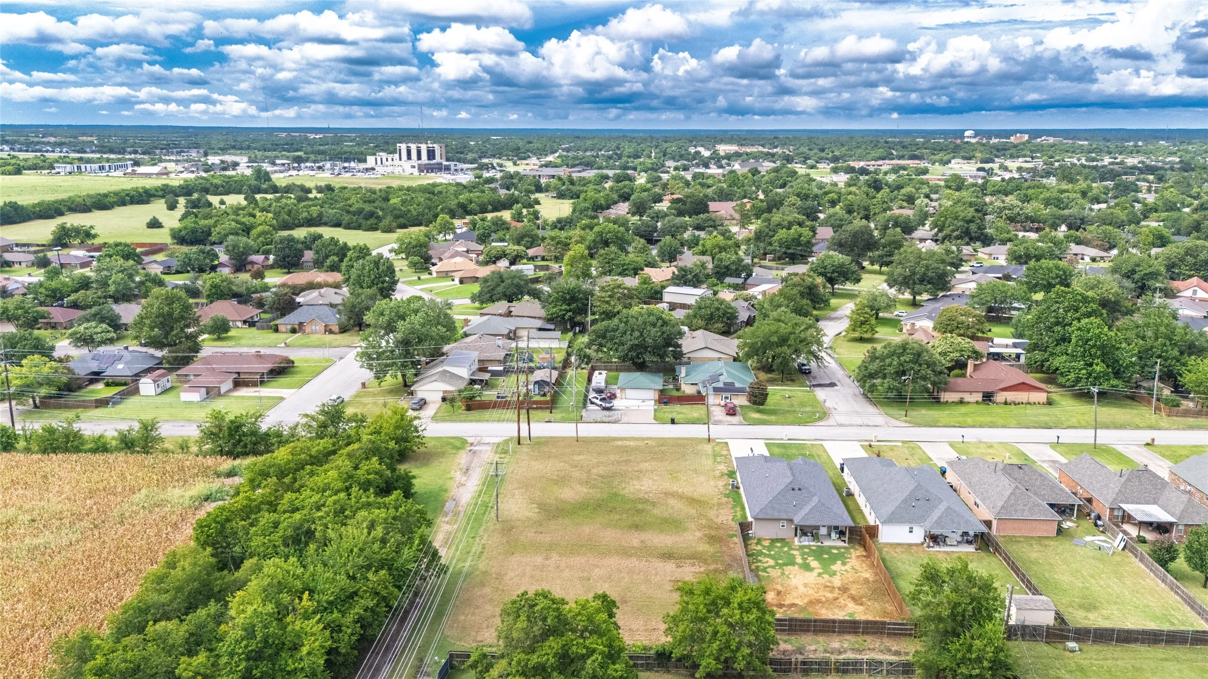Expansive aerial view showcasing a developed residential area with established homes and mature trees