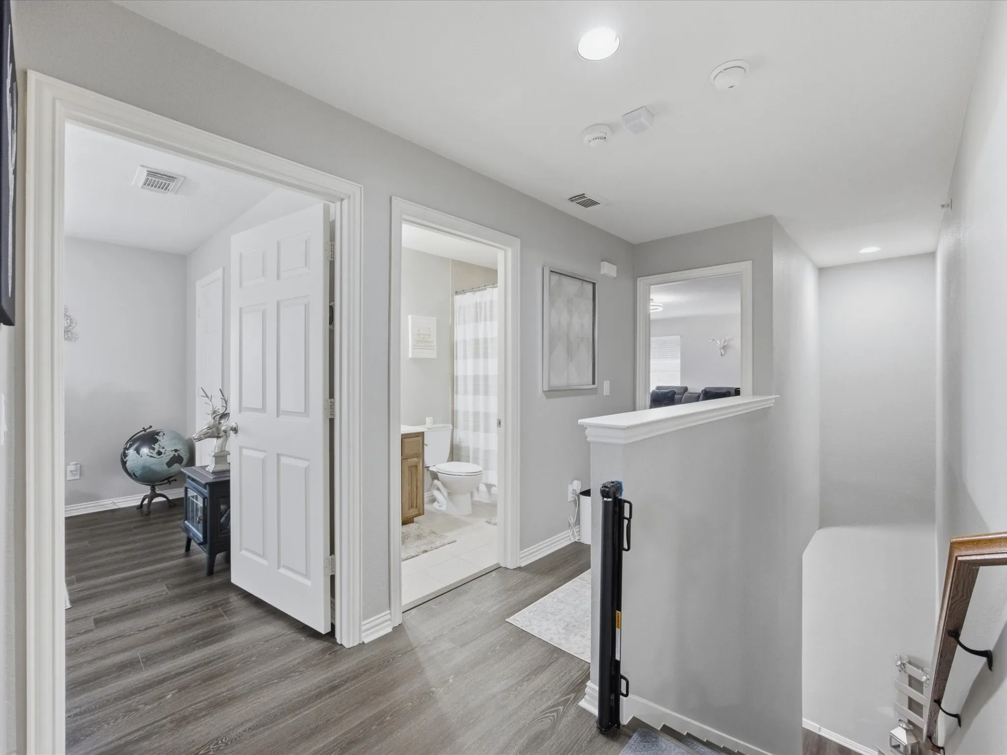 Upper-level hall with wood-finish flooring, recessed lighting, and a neutral wall palette