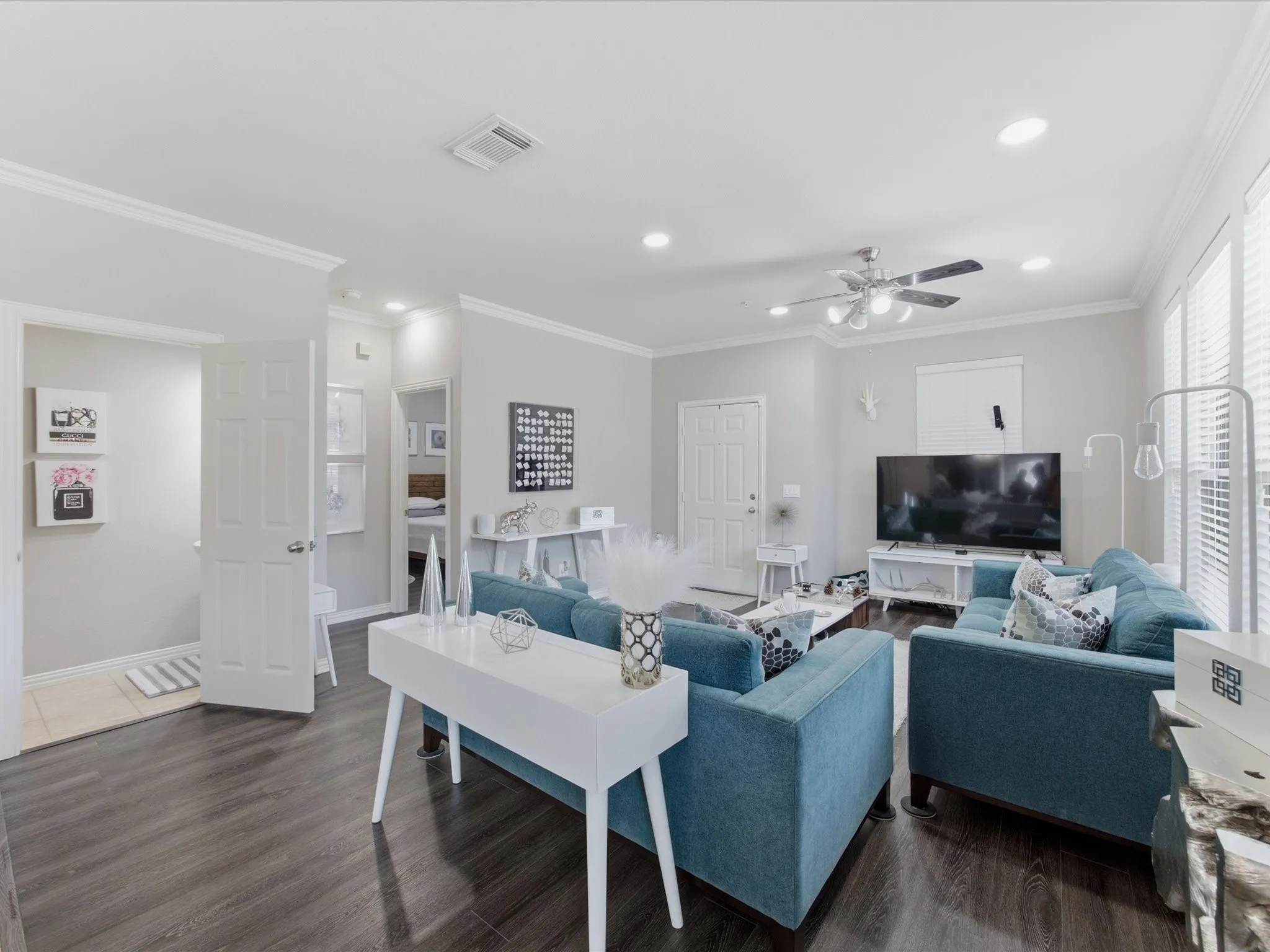 Spacious living area featuring dark wood-finish flooring, recessed lighting, and crown molding