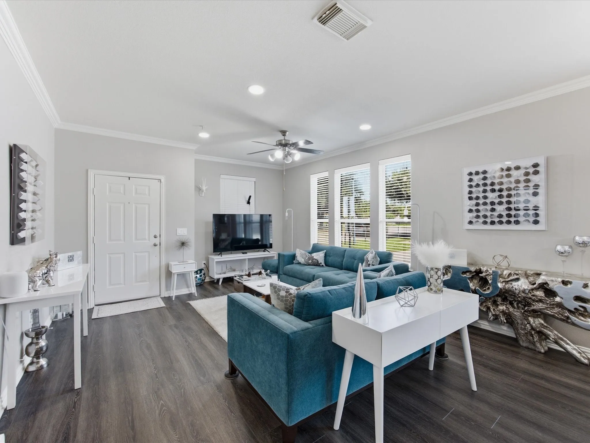 Spacious living area featuring wood-finish flooring, recessed lighting, and crown molding