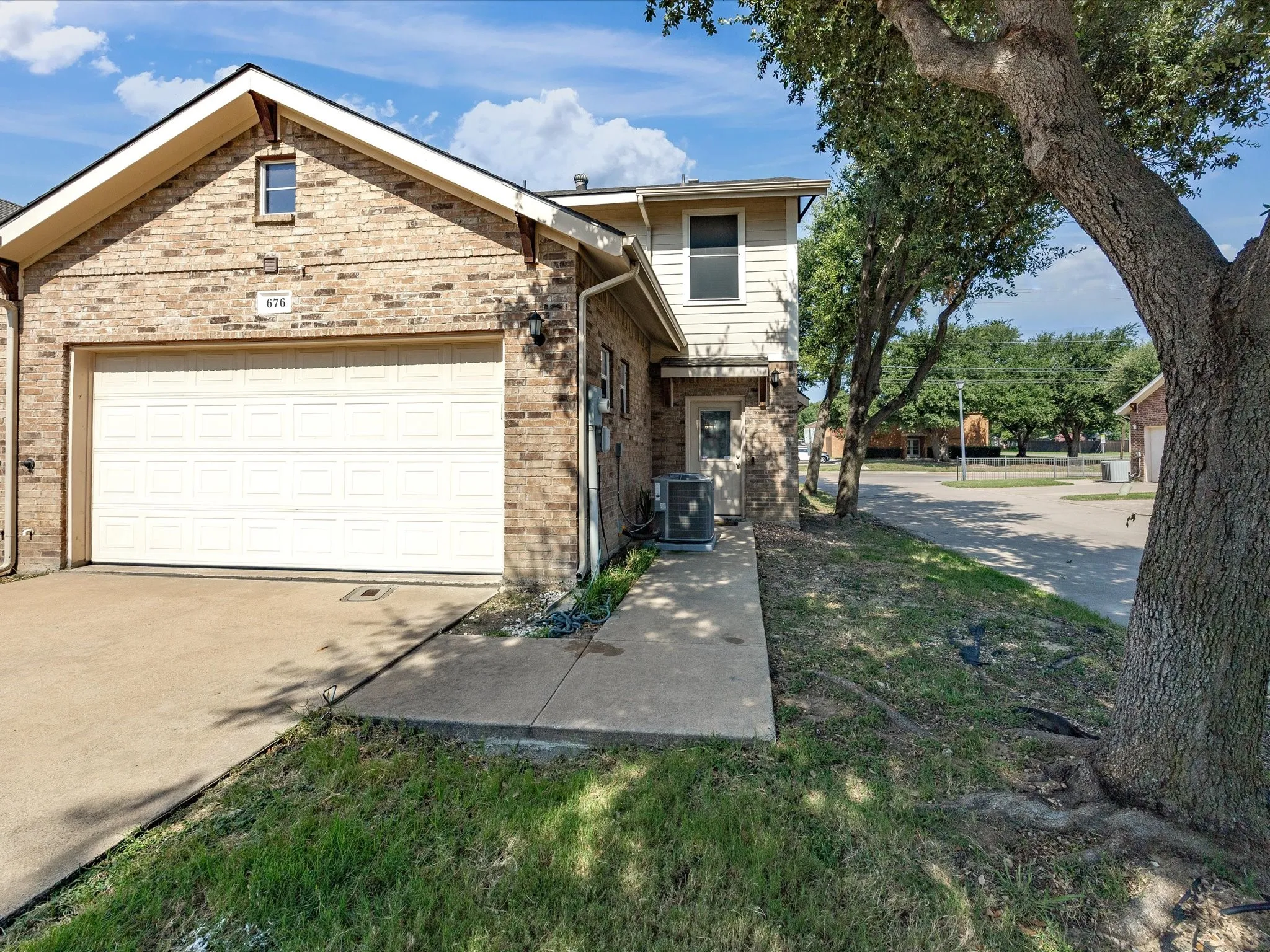 Brick exterior with an attached garage, featuring a panel-style garage door