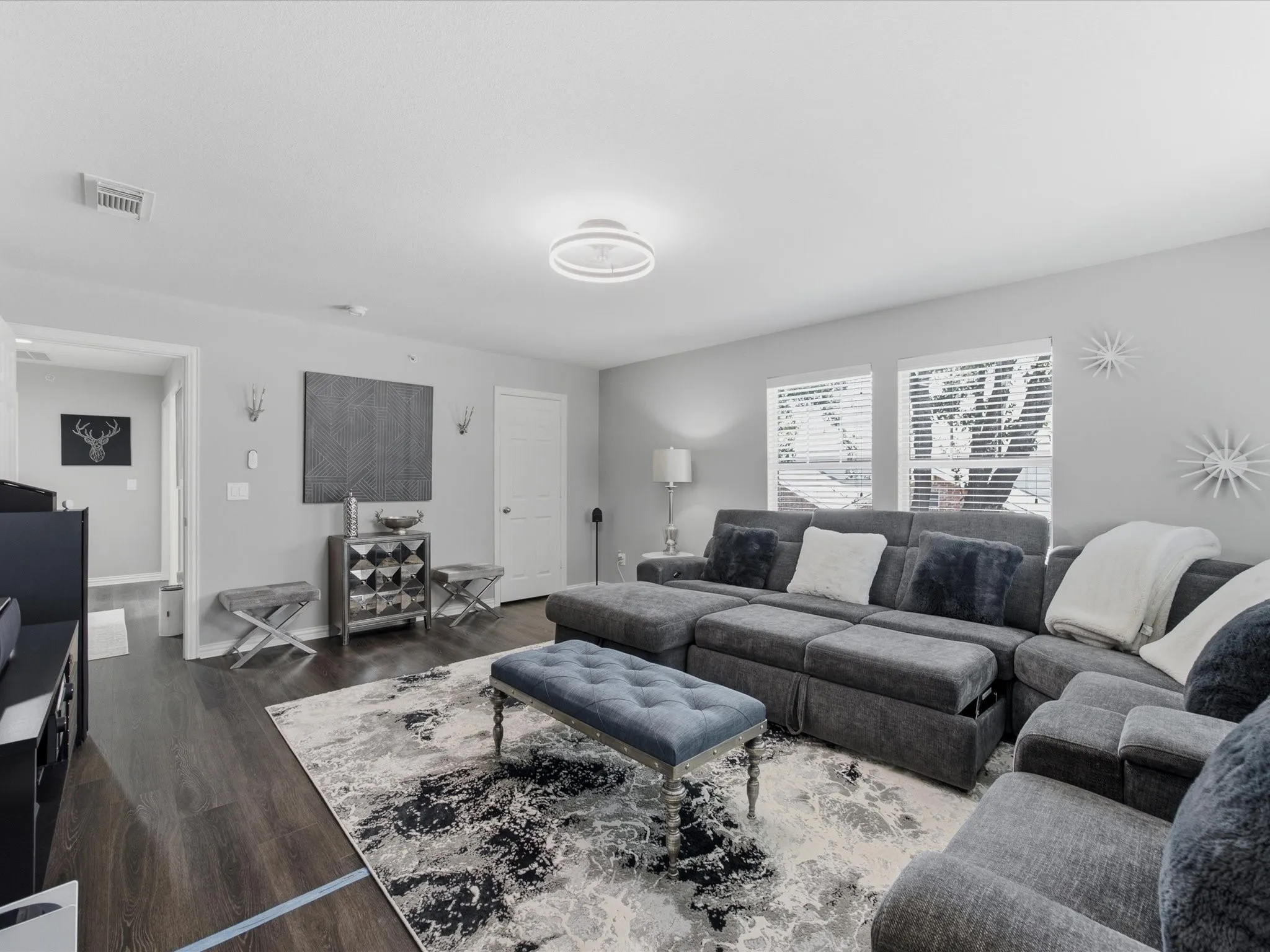 Spacious bedroom featuring wood-finish flooring, light gray walls, and white trim