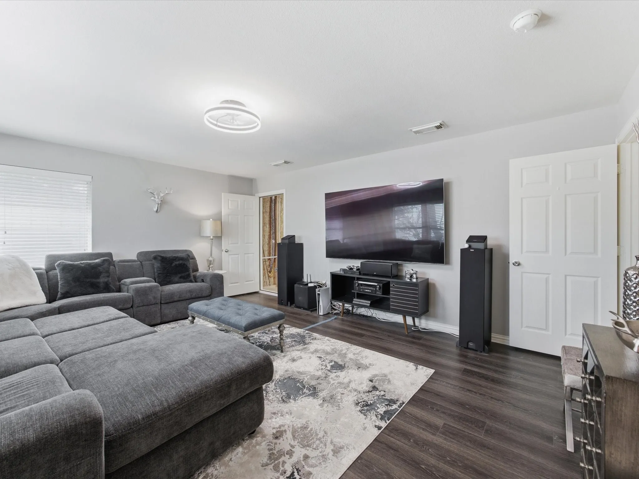 Spacious bedroom featuring wood-finish flooring and a contemporary overhead light fixture