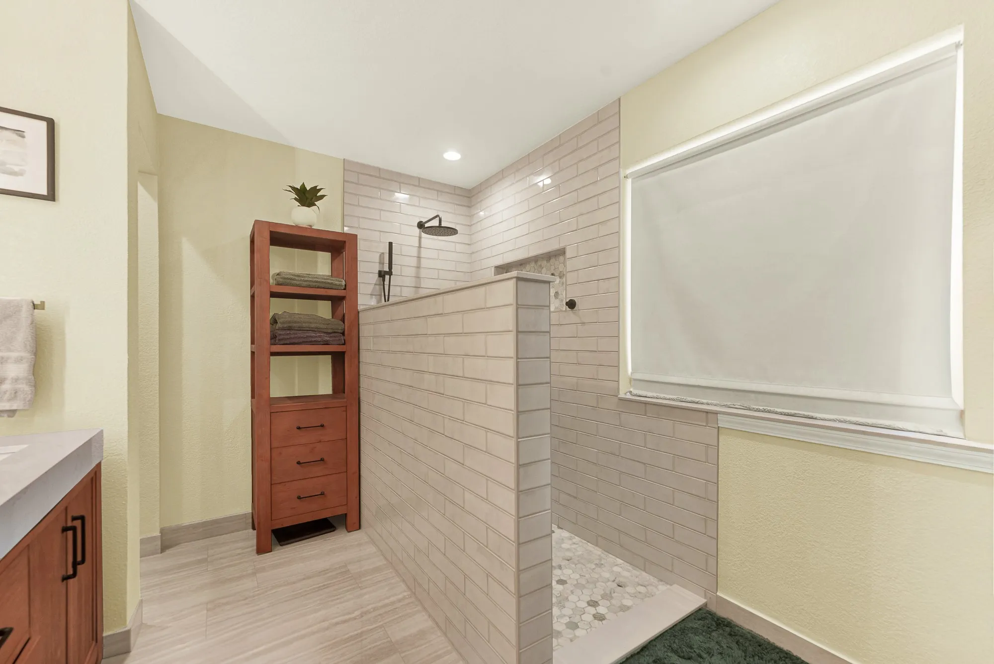 Walk-in shower featuring subway tile surround, hexagonal tile flooring, and a matte black rain showerhead