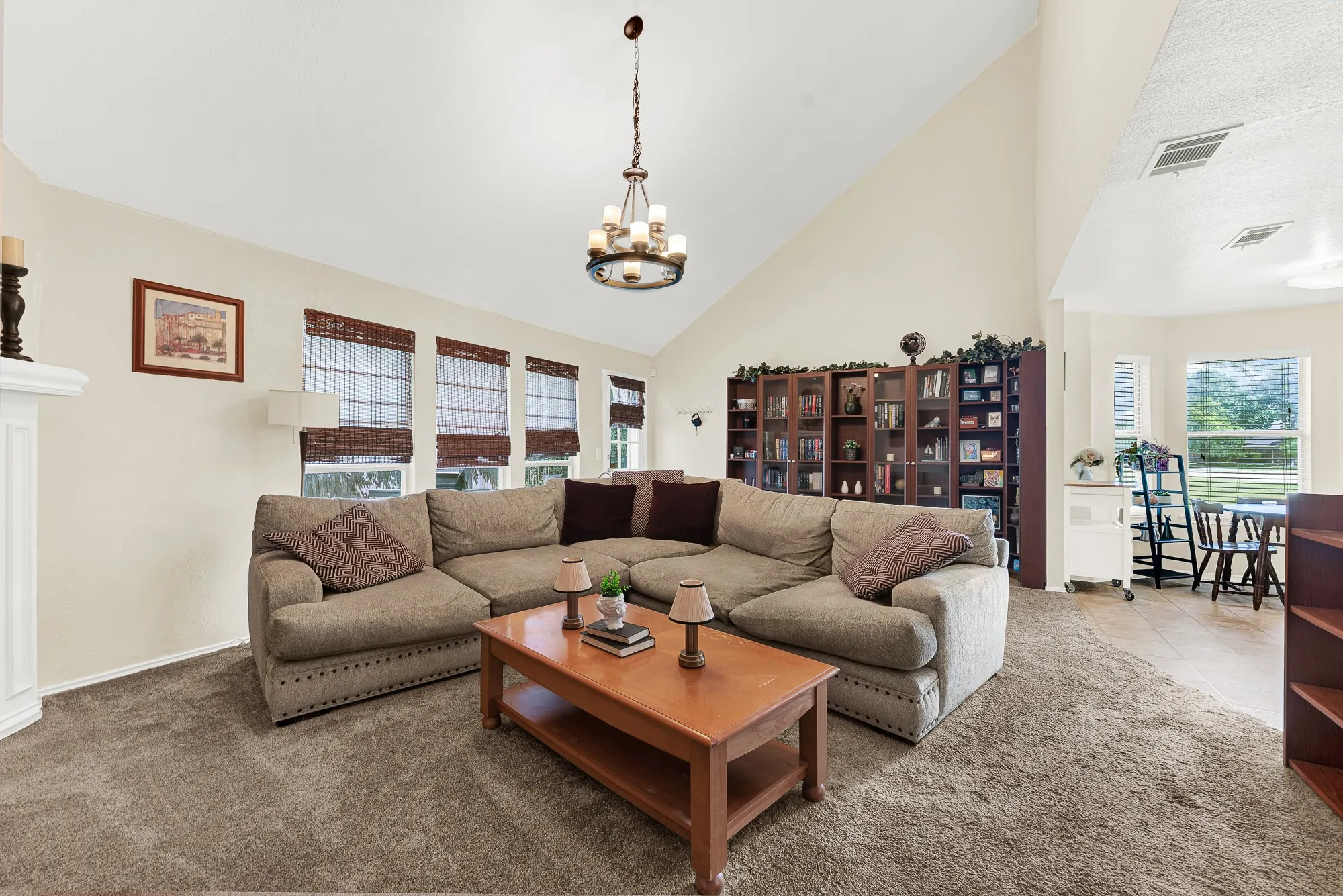 Living area featuring a vaulted ceiling and a central chandelier
