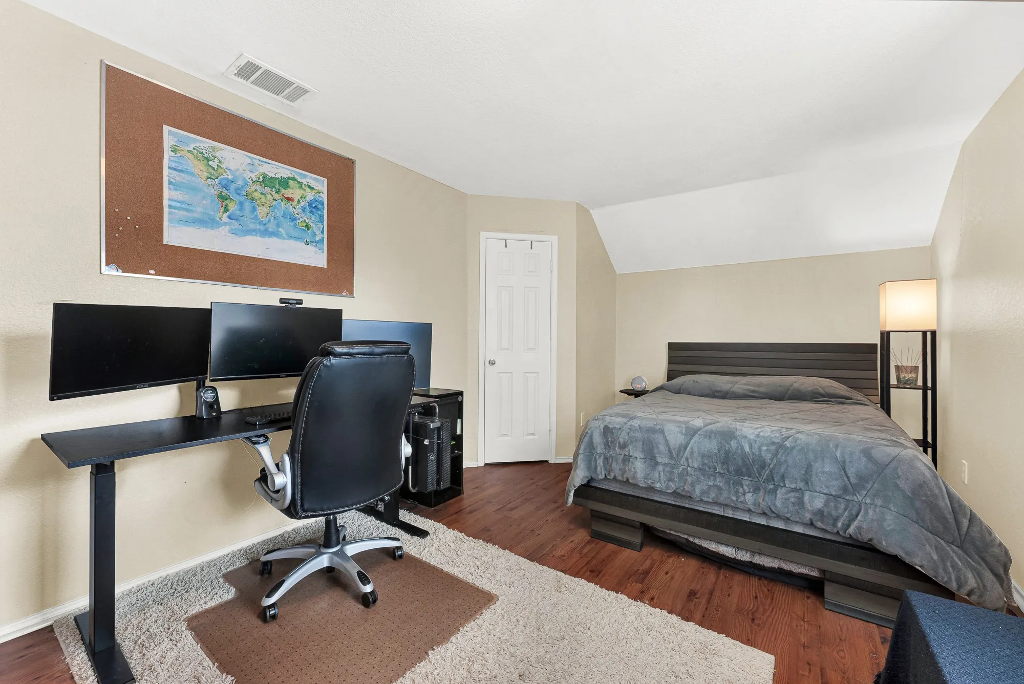 Bedroom featuring wood-finish flooring, neutral wall tones, and a paneled door