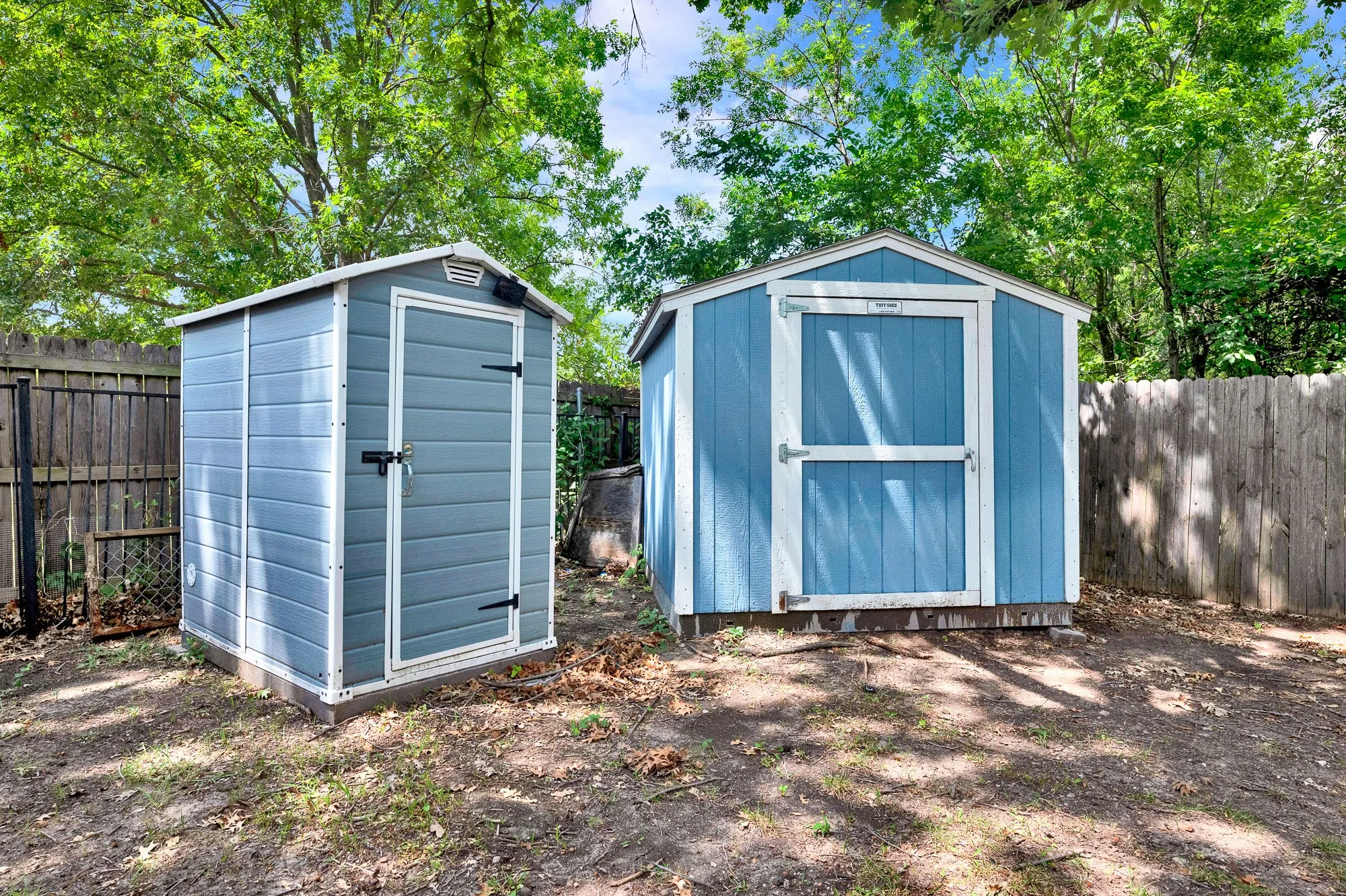 Two detached storage sheds featuring blue siding and white trim