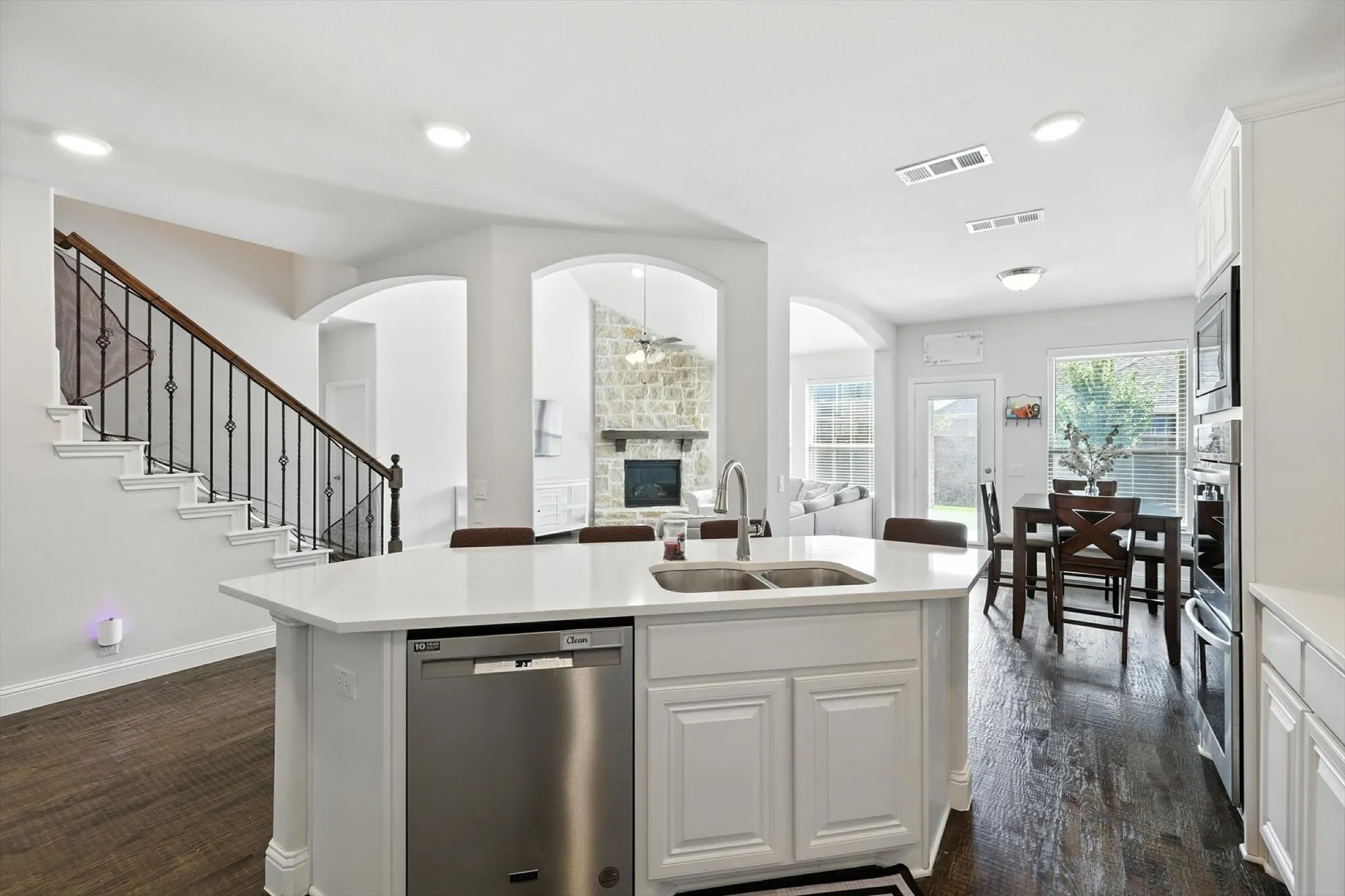 Kitchen with stainless steel appliances, a breakfast bar area, a center island with sink, and light countertops
