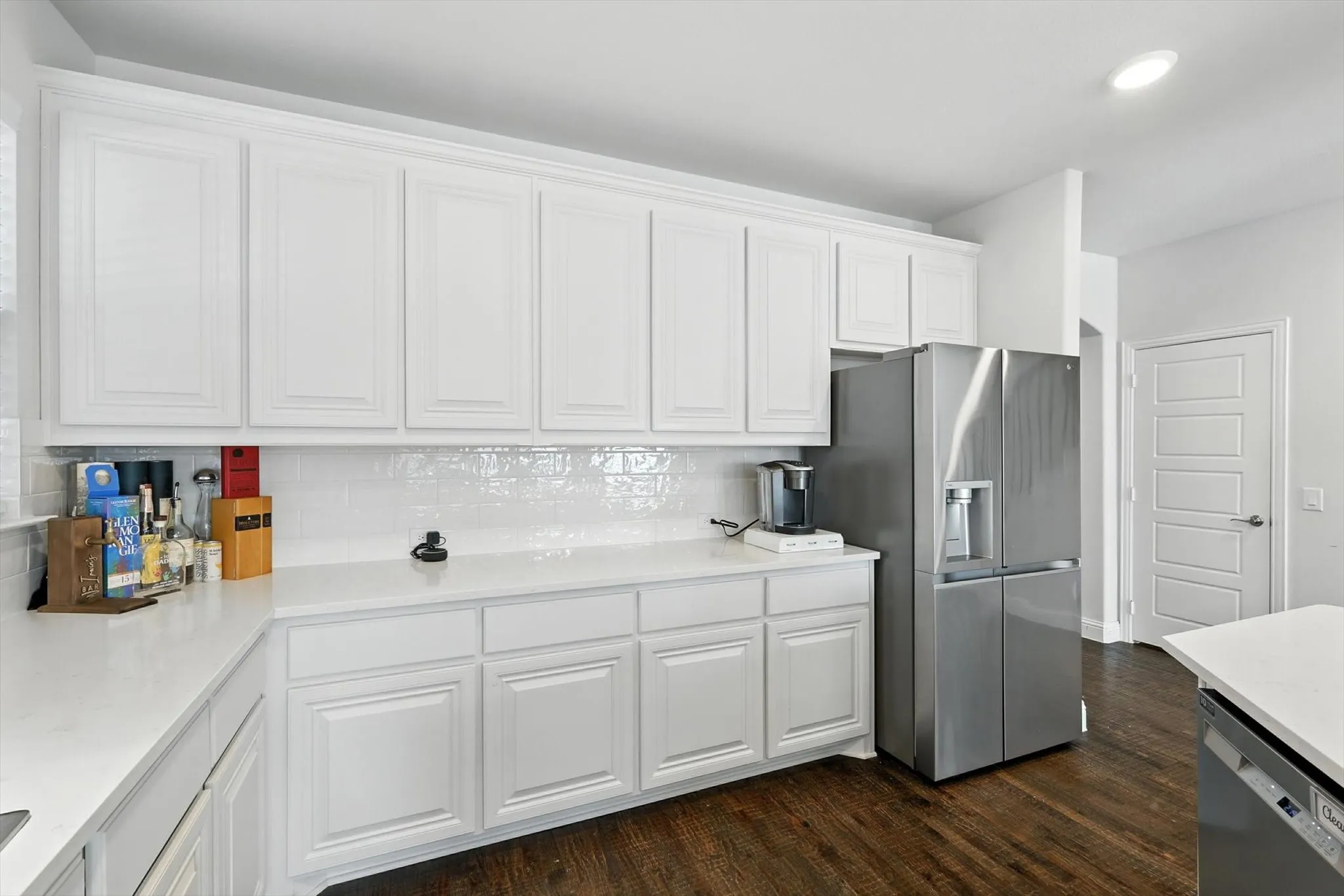 Kitchen with stainless steel appliances, a breakfast bar area, a center island with sink, and light countertops