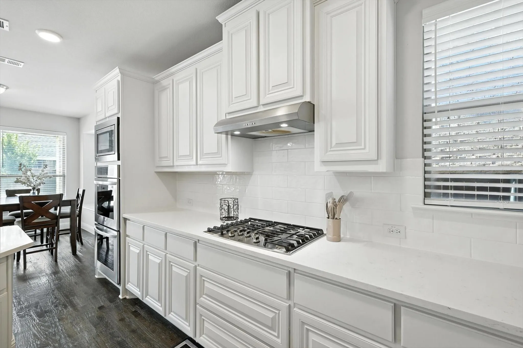 Kitchen with stainless steel appliances, a breakfast bar area, a center island with sink, and light countertops