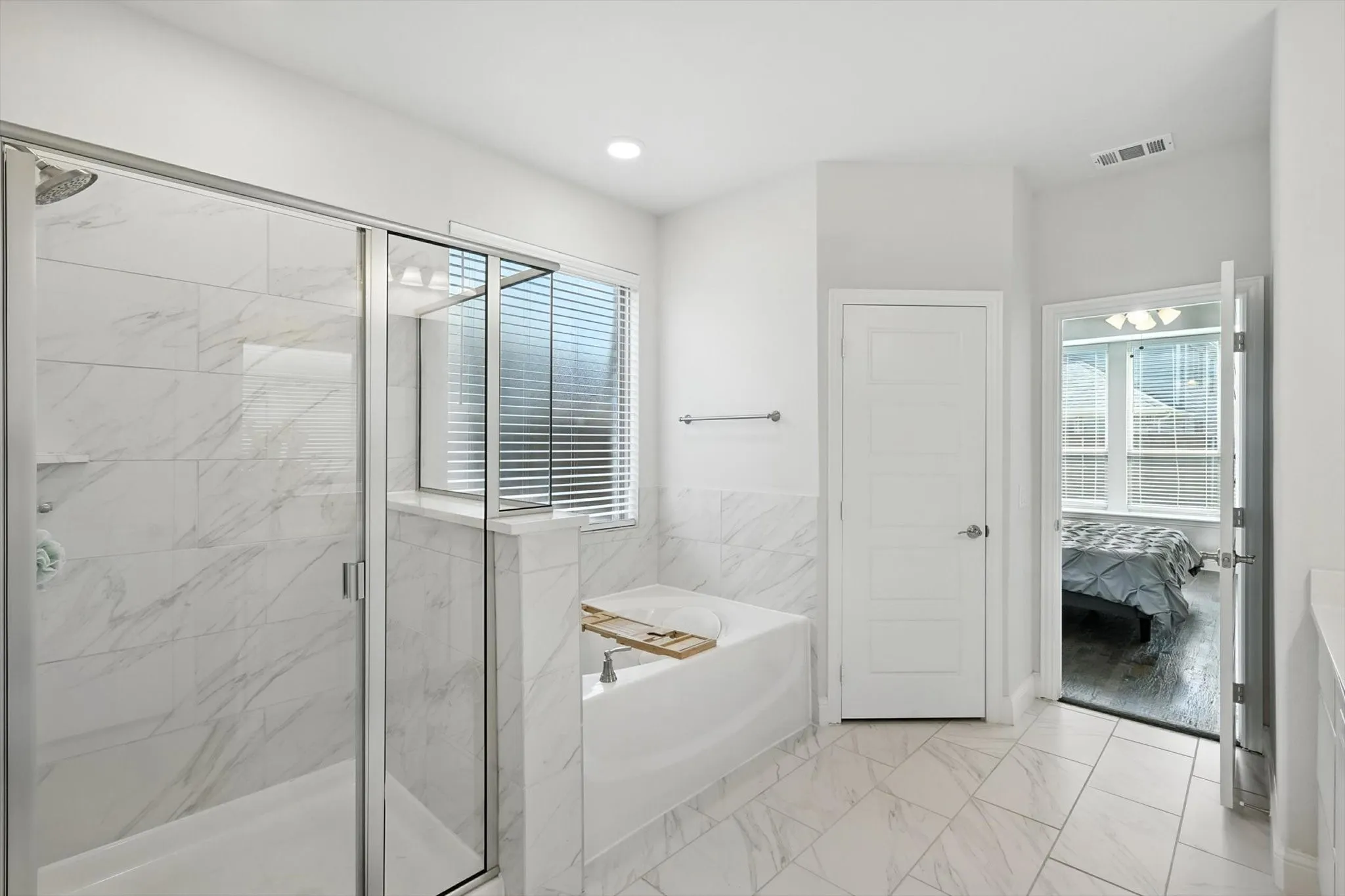 Primary Bathroom with soaking tub, separate shower, and dual vanities