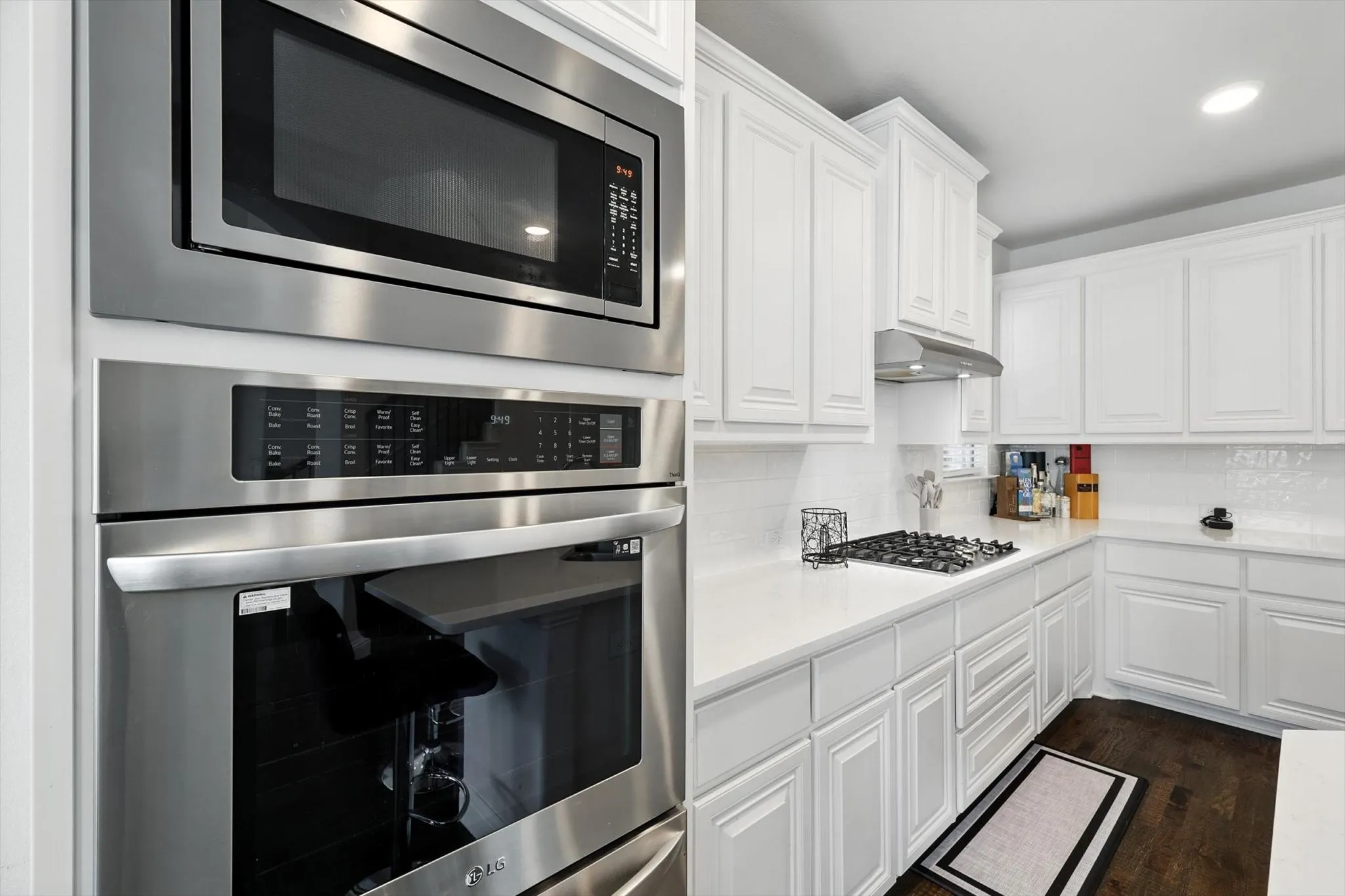 Kitchen with stainless steel appliances, a breakfast bar area, a center island with sink, and light countertops
