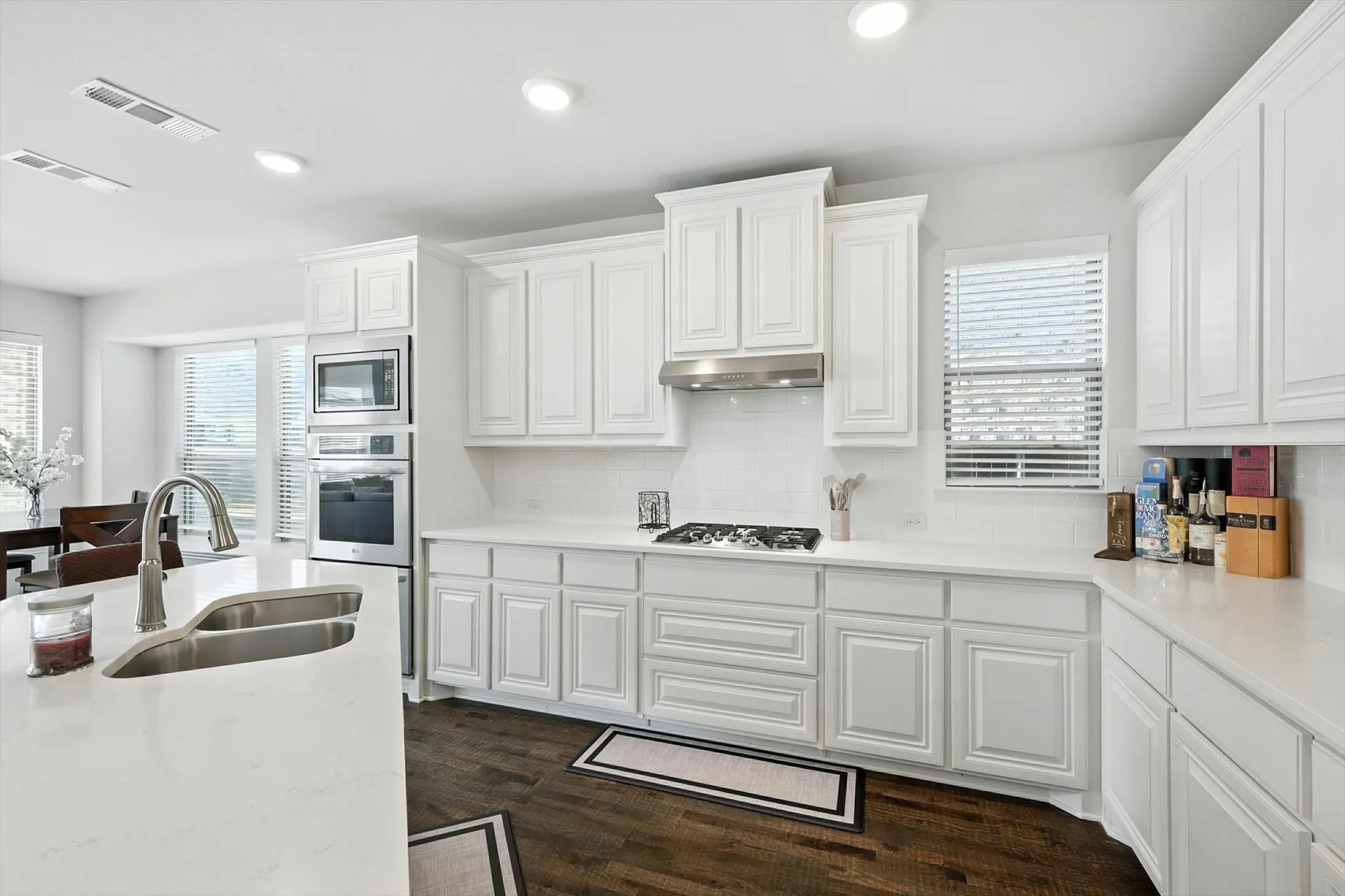 Kitchen with stainless steel appliances, a breakfast bar area, a center island with sink, and light countertops