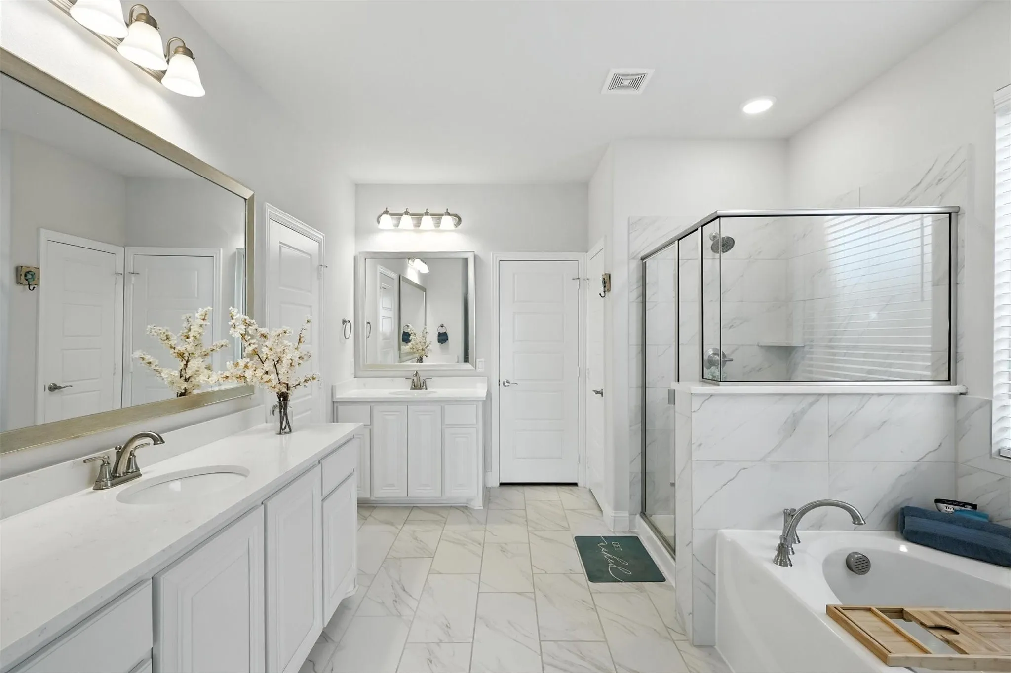 Primary Bathroom with soaking tub, separate shower, and dual vanities