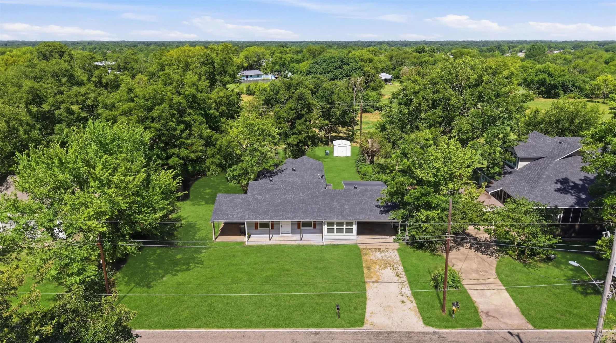 Ranch-style exterior with a dark shingle roof and light-colored siding