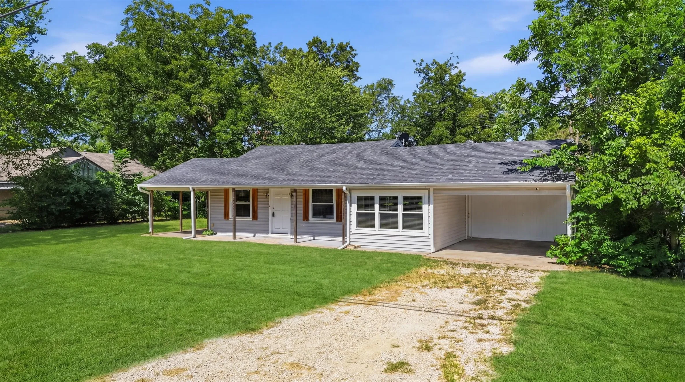 Single-story residence featuring light gray siding and a dark shingle roof