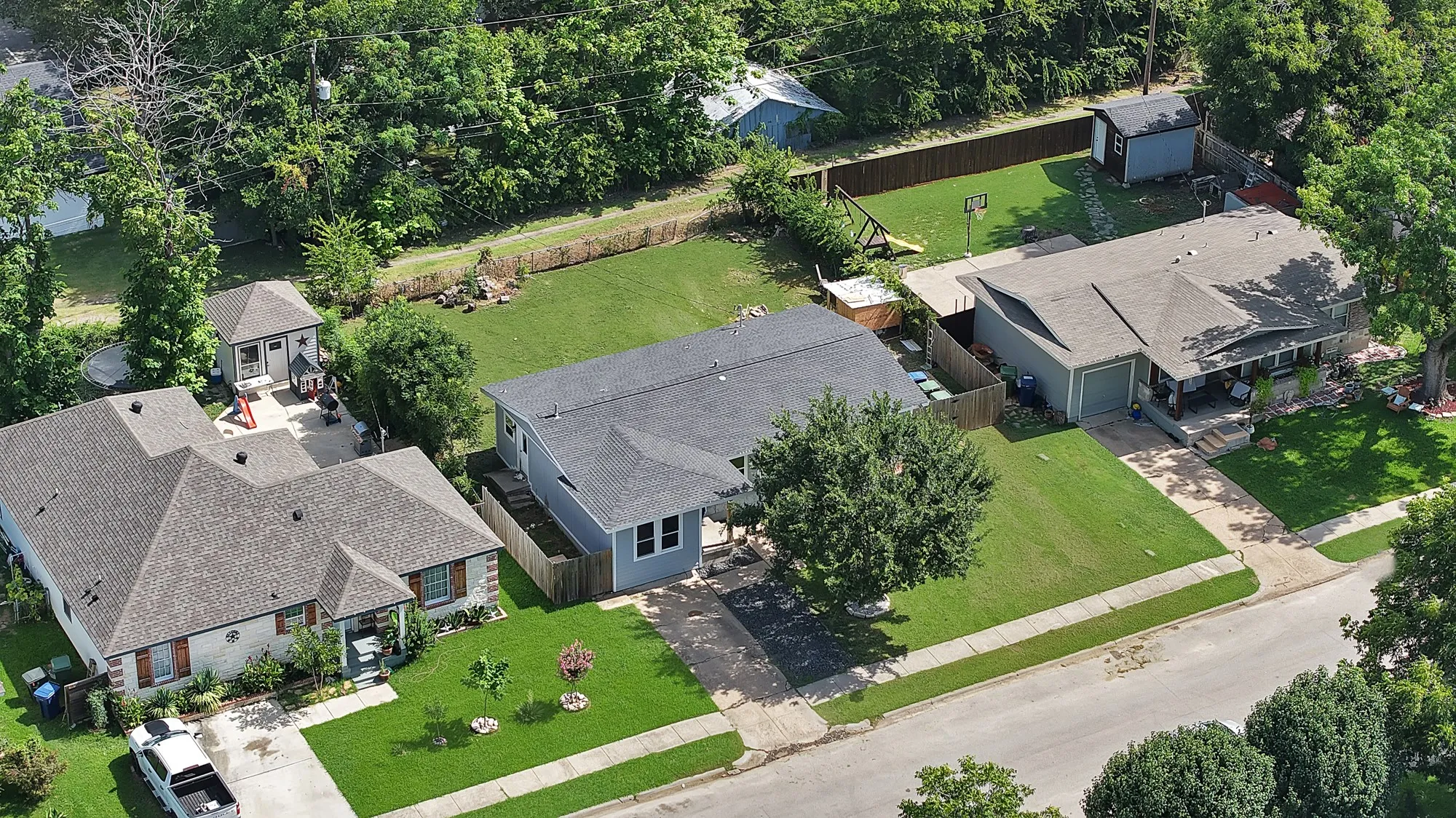 Aerial perspective showcasing three residential properties with varied architectural styles