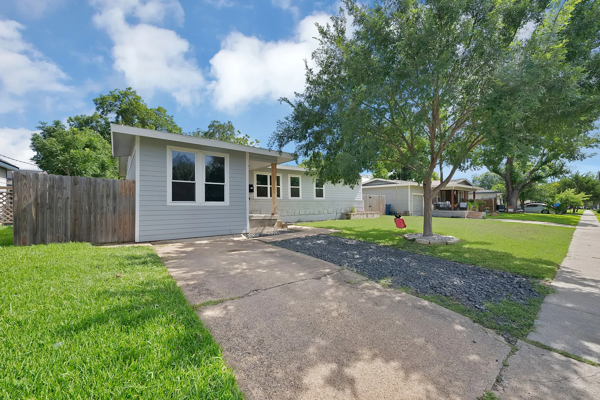 Contemporary-style home featuring light gray siding, white trim, and a low-sloping roofline