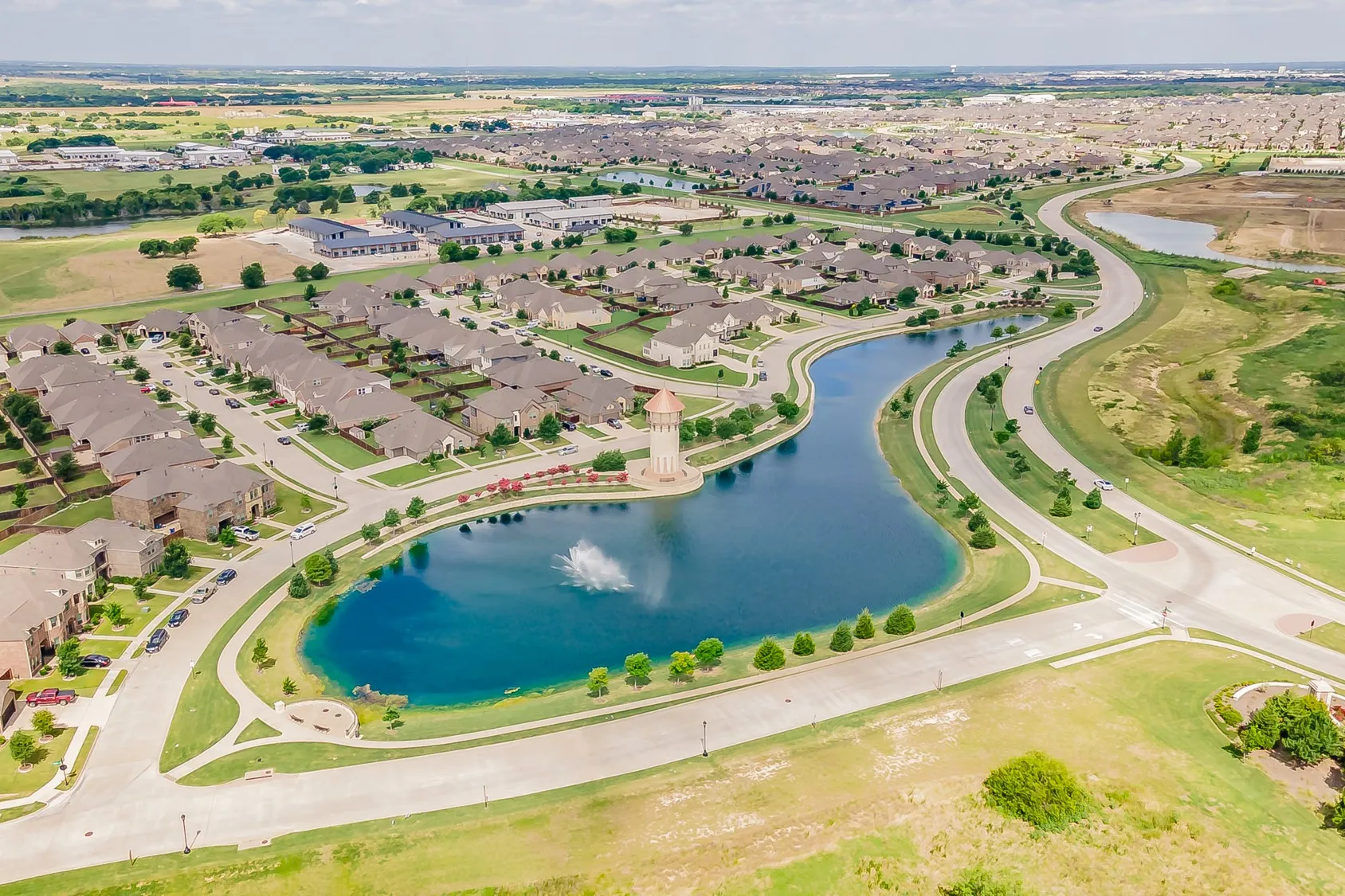 Expansive residential community featuring ponds with fountain, surrounding green spaces, walking trails and a distinctive lighthouse tower