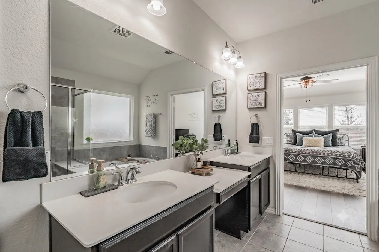 Another view of primary bathroom featuring vanity area and dual sinks