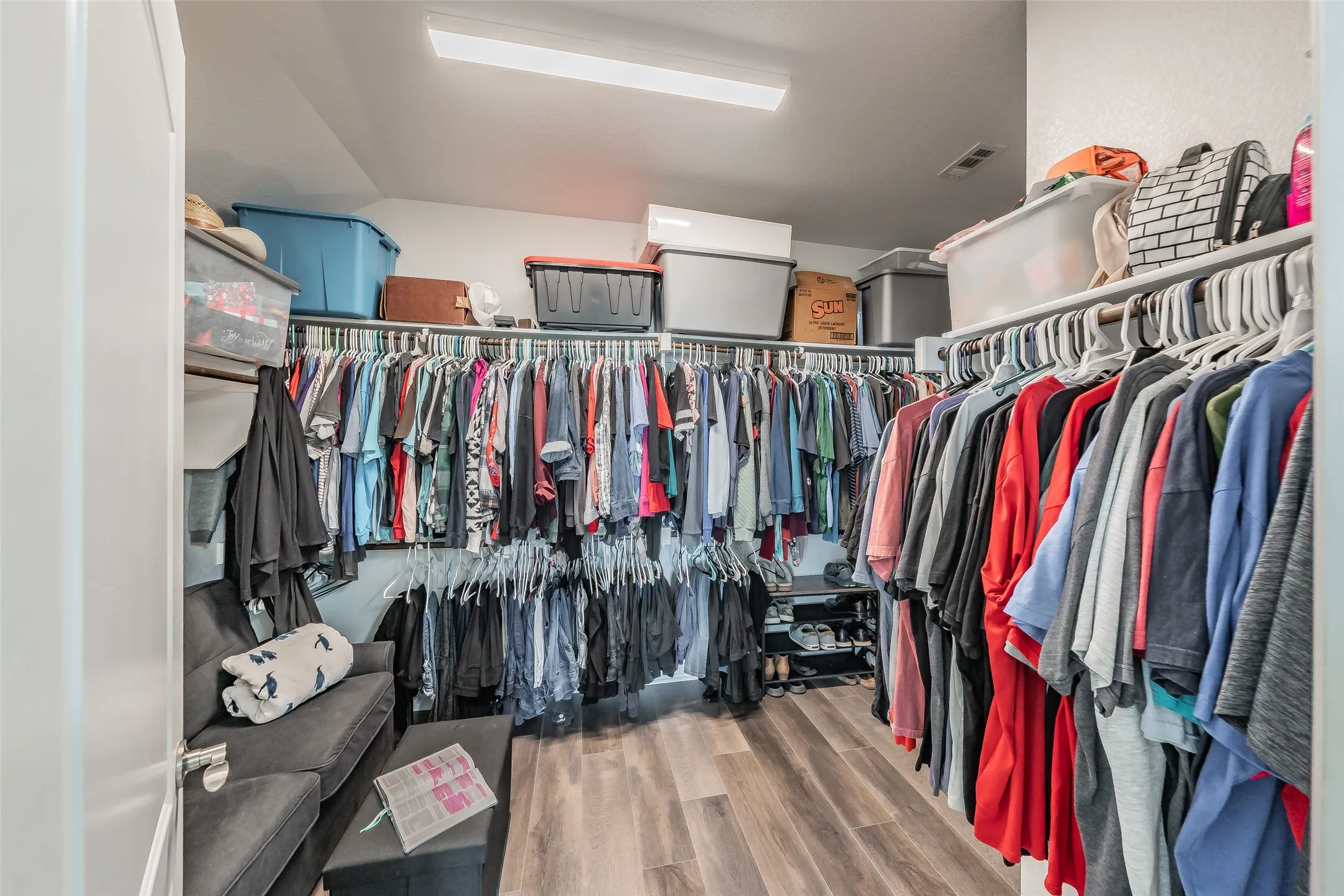 Walk-in primary closet featuring extensive built-in shelving, space for storing and more