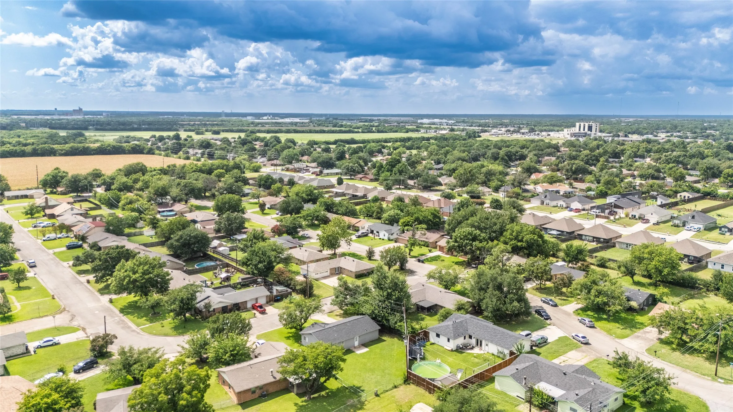 Aerial perspective showcasing a residential area with mature trees and a structured street layout