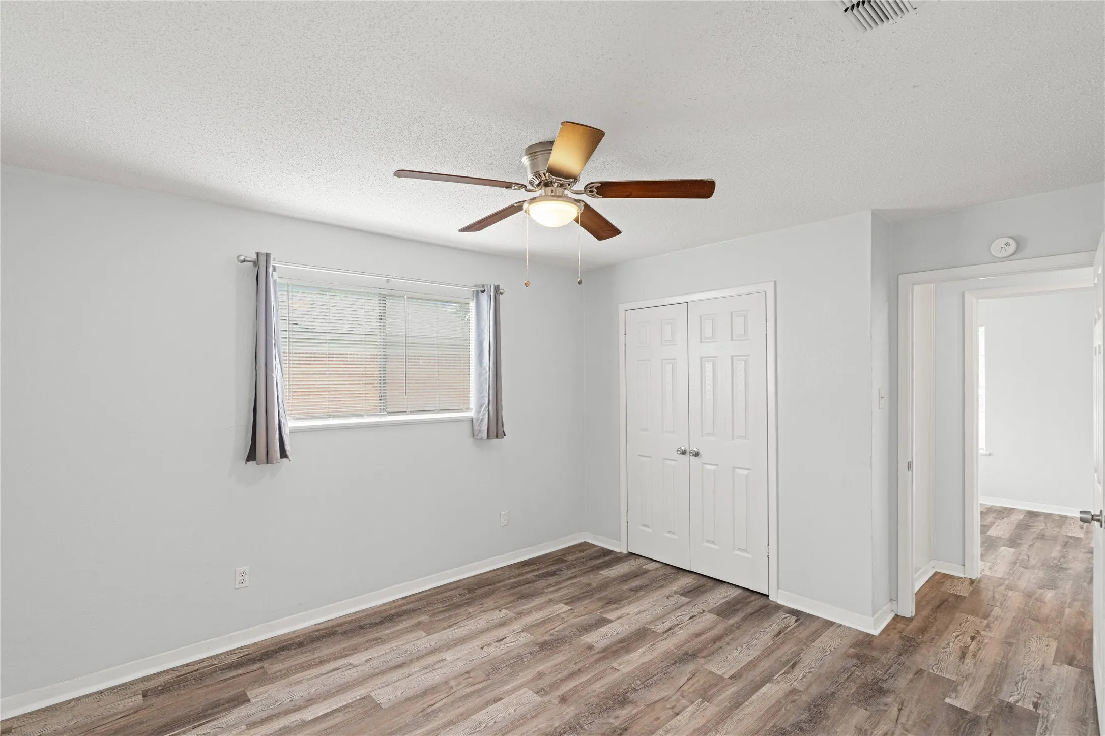 Bright room featuring wood-finish flooring and light-toned walls
