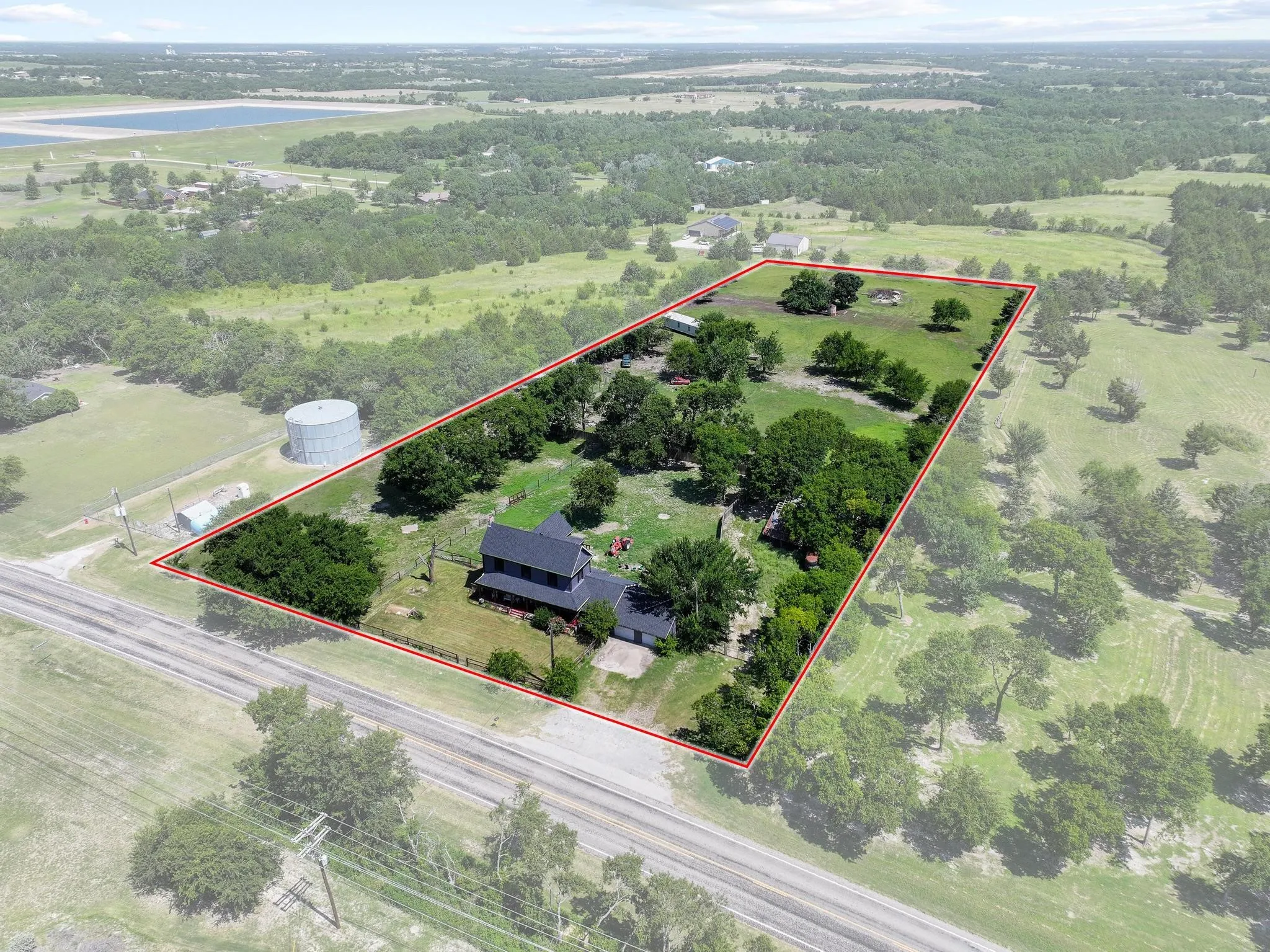 Expansive rural property featuring a two-story residence, mature trees, and a substantial land parcel